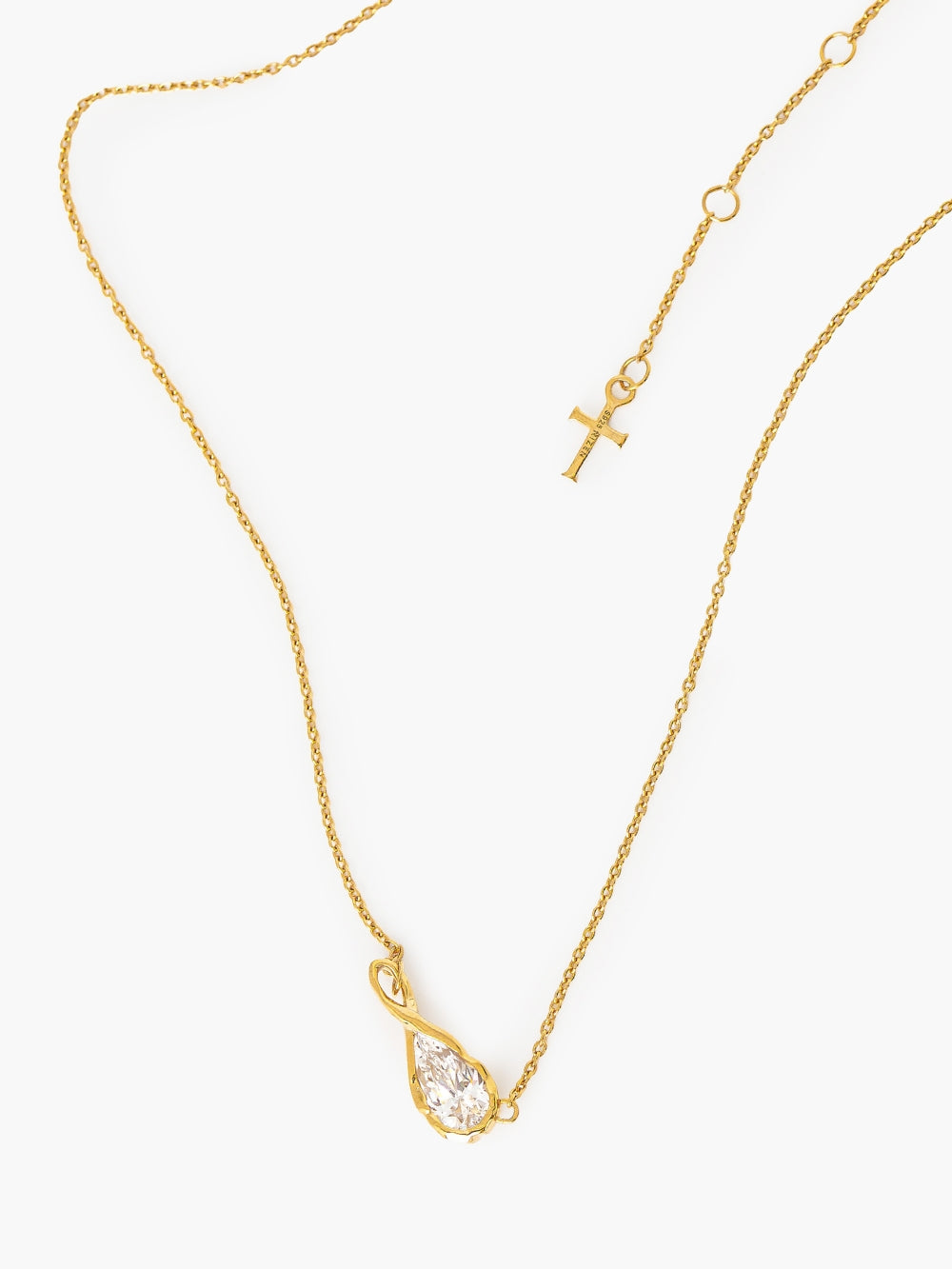 A delicate gold chain necklace featuring a teardrop-shaped simulated diamond pendant held in an infinity loop setting, designed by faith based Rizen Jewelry. Necklace is against a white backdrop and shows their signature Cross Pendant tag.