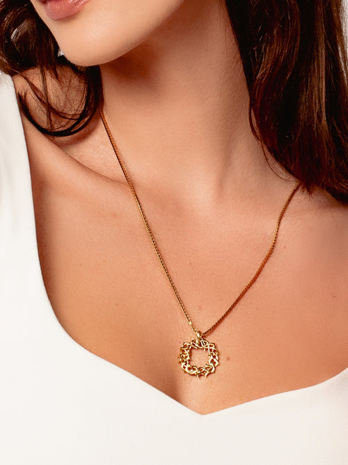 Women's Christian jewelry model is wearing the Crown of thorns large pendant necklace in 18k gold plated from the Insignia collection. A timeless baptism gift by Rizen Jewelry.