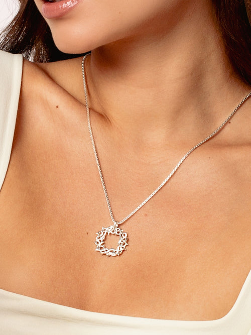 Women's Christian jewelry model is wearing the Crown of thorns large pendant necklace in sterling silver from the Insignia collection. A wonderful Christian Jewelry Gift by Rizen Jewelry.