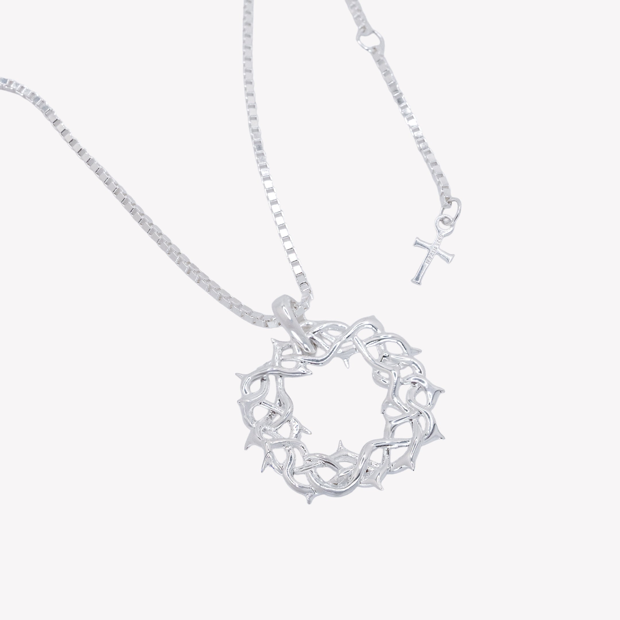 Large sterling silver  Crown of Thorns Pendant hangs on a box chain necklace with the signature Rizen cross tag from the Insignia Collection by Rizen Jewelry. 