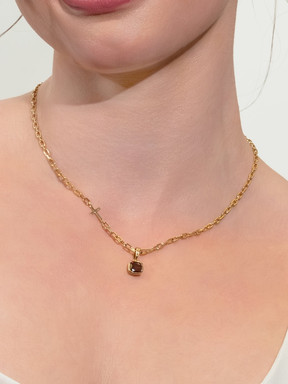 Women's Christian jewelry model wears the gold mini chain breaker cross necklace featuring the Garnet Fully Known prayer pendant. 
