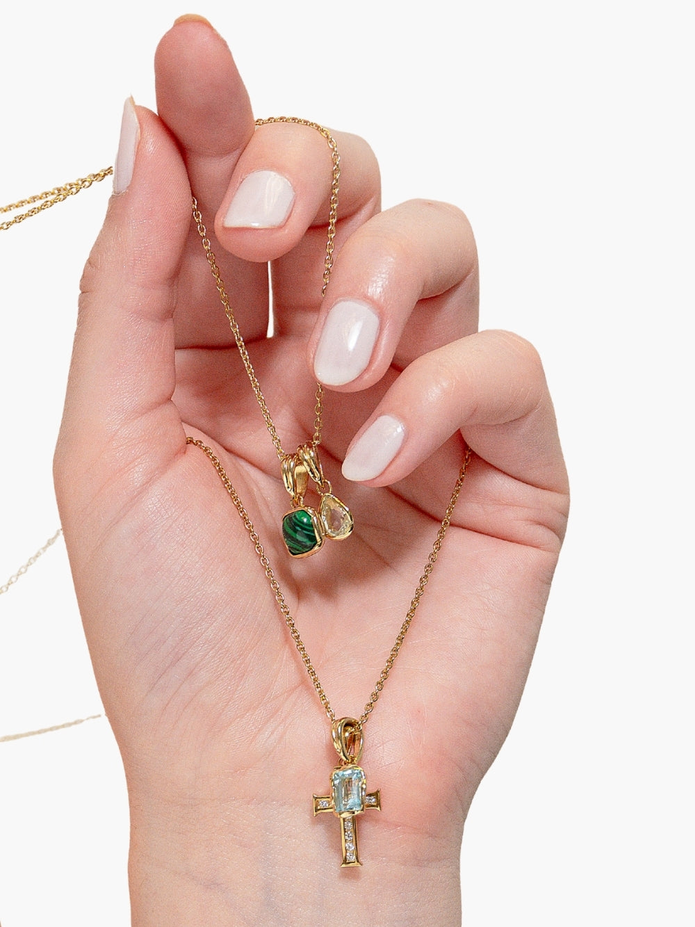 Rizen Jewelry Green Quartz Fully Known Prayer Pendant cradled in an 18 karat gold plated finish featured on a chain held by a woman's Christian Jewelry Hand Model 