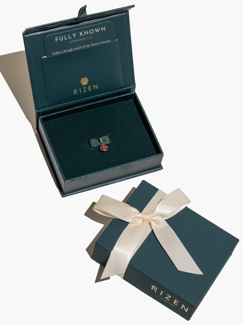 Ruby Fully Known Prayer Pendant by Rizen Jewelry features a round brilliant-cut light lab ruby stone is cradled in 18k gold plating over sterling silver setting. The pendant symbolizes passion, redemption, value, and the month of July. A beautiful presentation with the Rizen Jewelry gift packaging 