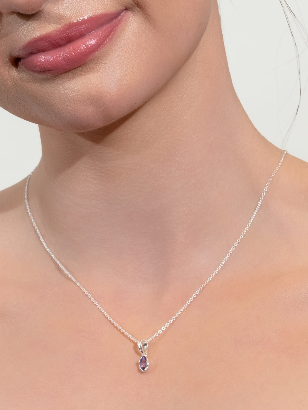 Women's Christian jewelry model wears the Light Amethyst Fully Known Prayer Pendant by Rizen Jewelry featuring a  luminous marquis cut light amethyst pendant, reflecting honor, peace, royalty, and the sweet heart of February, cradled gently in refined sterling silver. Featured on a subtle cable chain necklace 