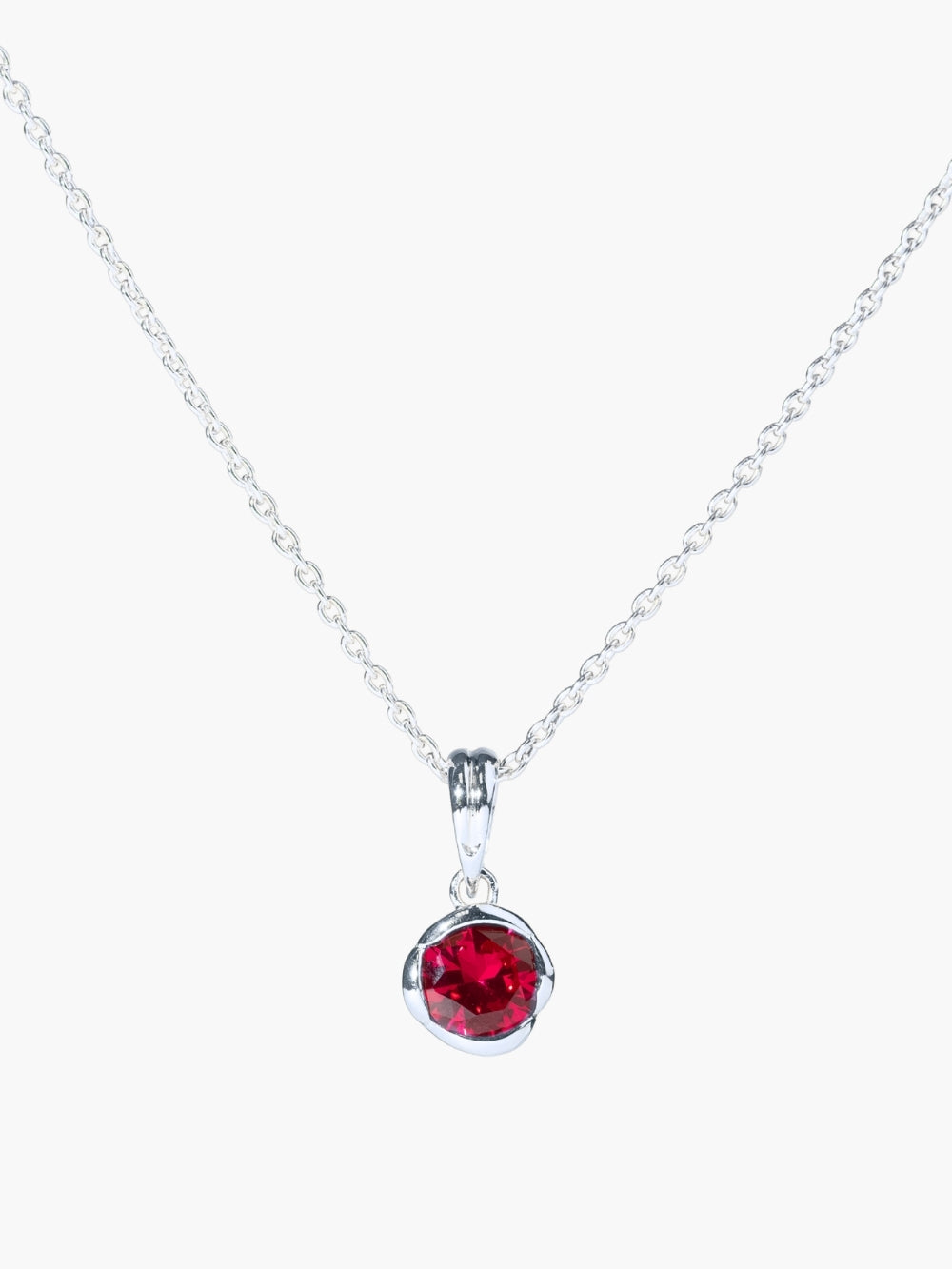 The Ruby Fully Known Prayer Pendant by Rizen Jewelry features a  round brilliant-cut light lab ruby stone cradled in a sterling silver setting. The pendant symbolizes passion, redemption, value, and the month of July. Featured on a sleek cable chain. 