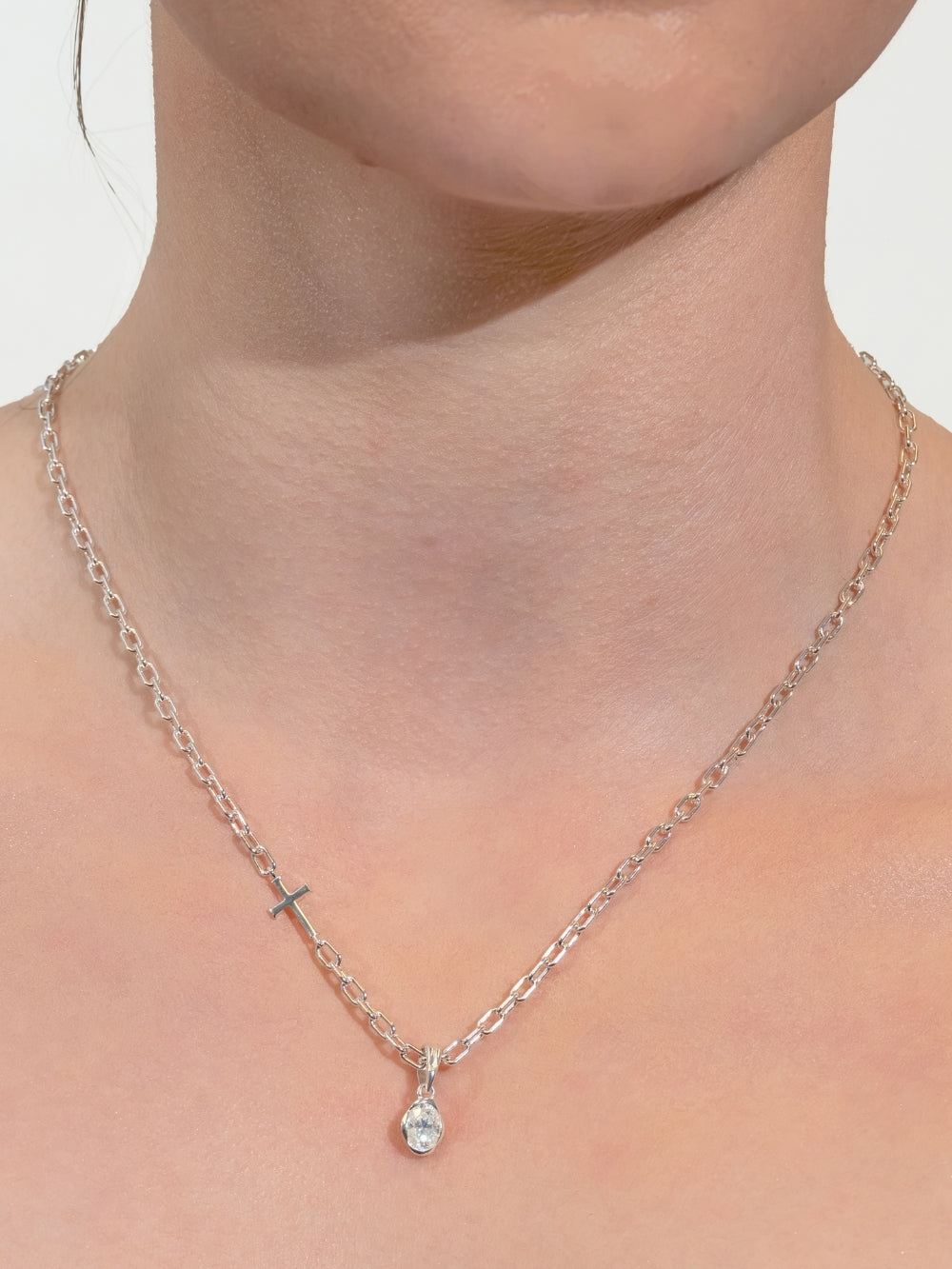 Women's Christian jewelry model wears the Mini Chain Breaker Necklace featuring the White Sapphire Fully Known Prayer Pendant by Rizen Jewelry features An oval brilliant cut white sapphire stone is cradled in 18k gold plating over sterling silver setting. The pendant symbolizes Purity, New Identity, Innocence, and the month of April.