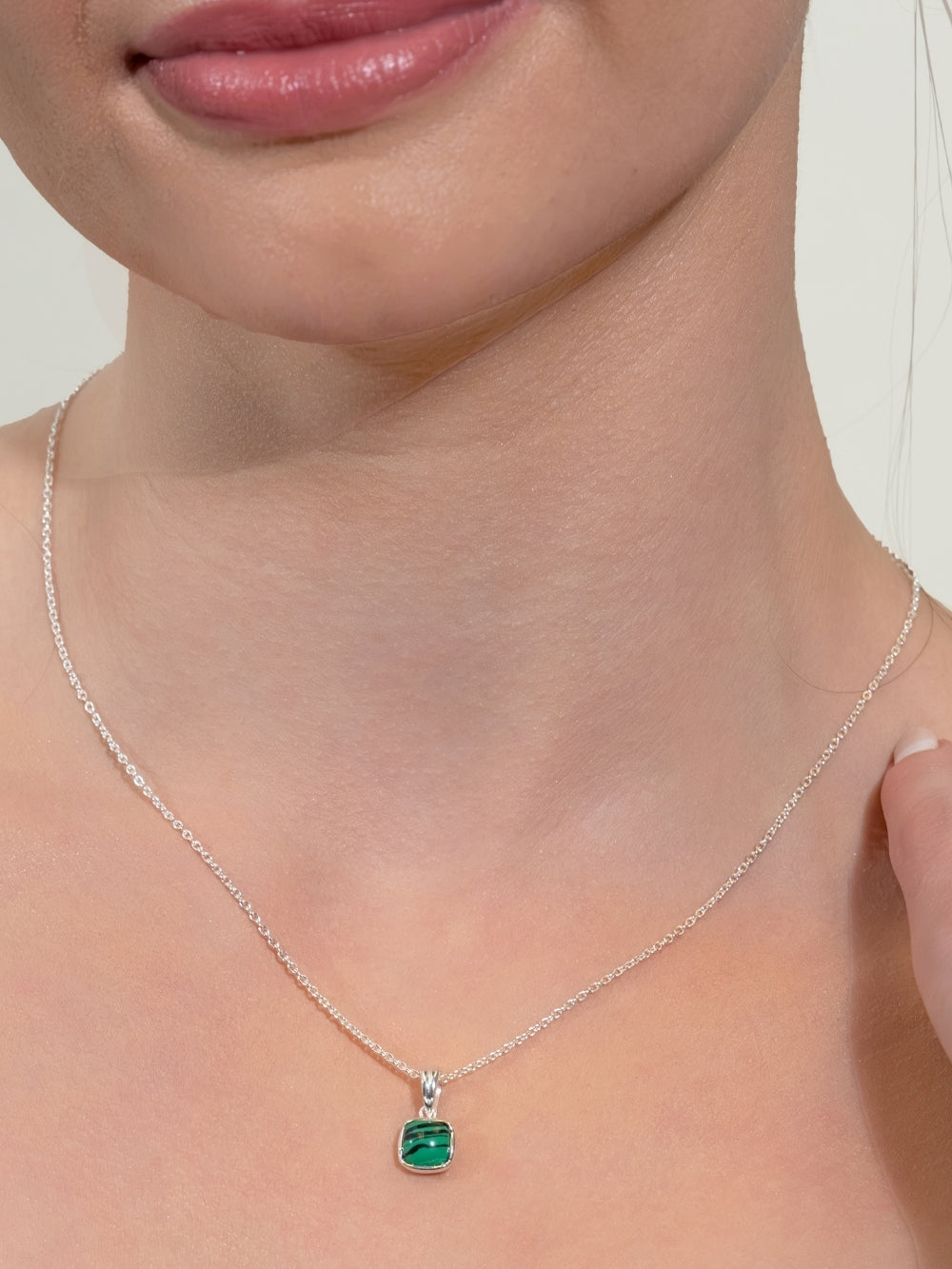 Woman's Christian jewelry model wearing the Malachite Fully Known Prayer Pendant by Rizen Jewelry on a plain cable chain.