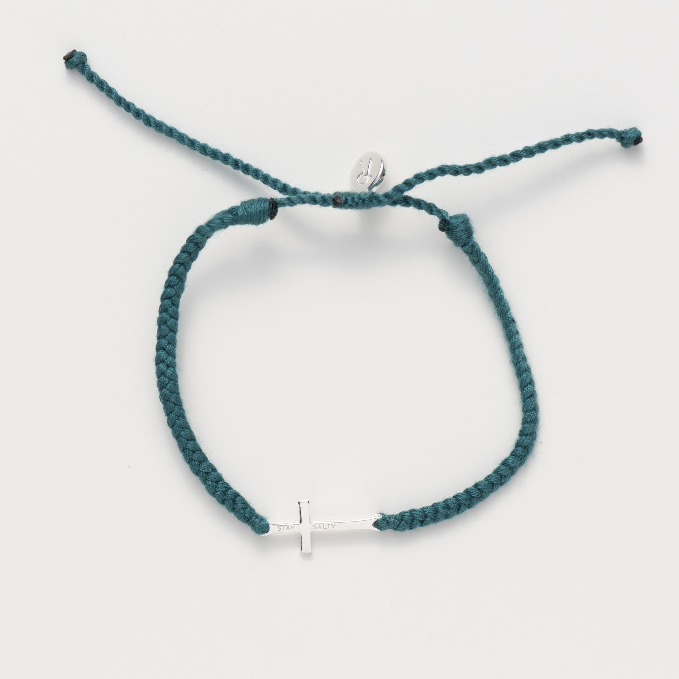 Cross bracelet engraved STAY SALTY set on a naturally dyed azure blue hand-braided, cotton cord friendship bracelet with a  Sterling Silver finish from the Made4Ministry Collection by Rizen Jewelry. 