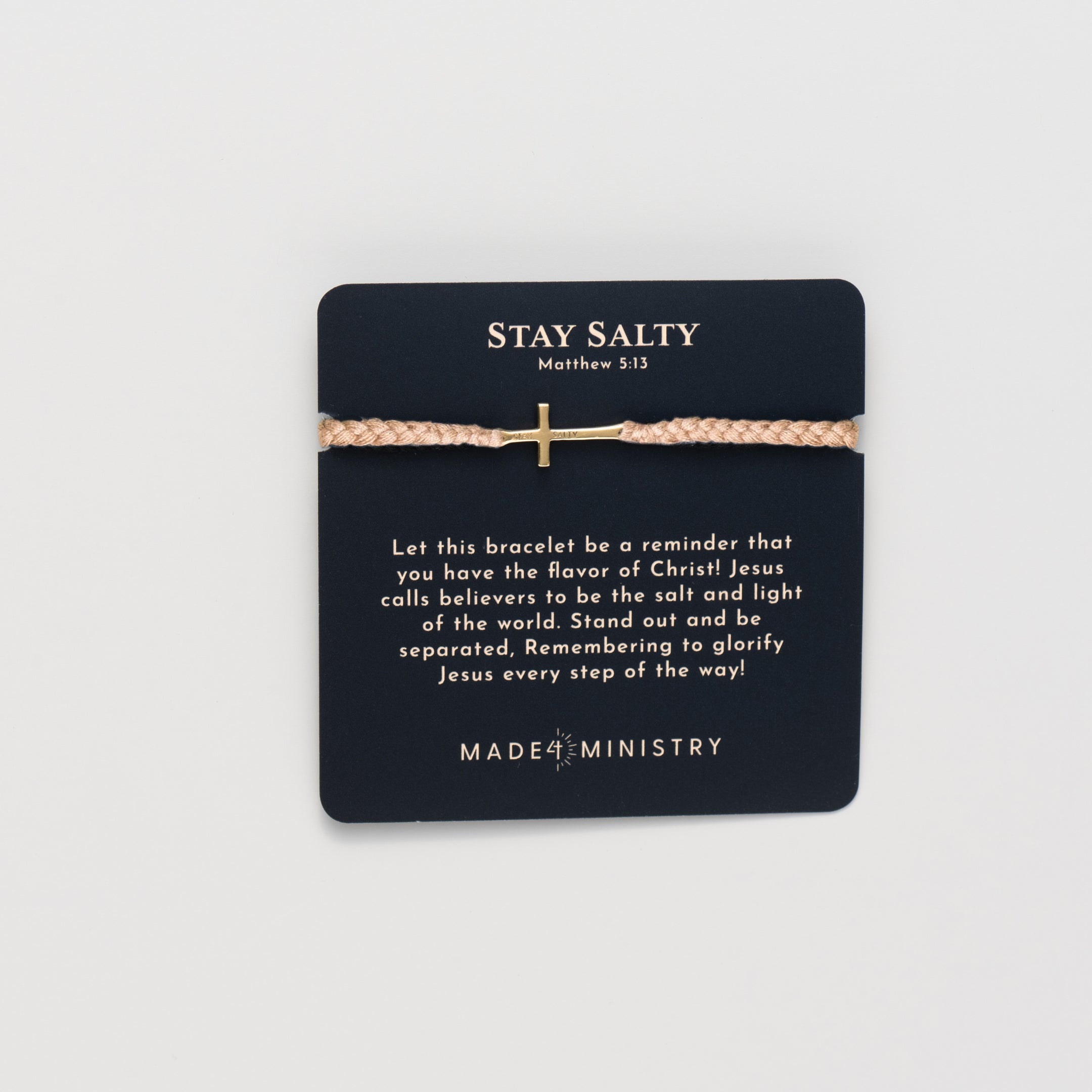 Cross bracelet engraved STAY SALTY set on a naturally dyed khaki hand-braided, cotton cord friendship bracelet with a gold or sterling silver finish from the Made4Ministry Collection by Rizen Jewelry. Featured on a Devotion Card. 