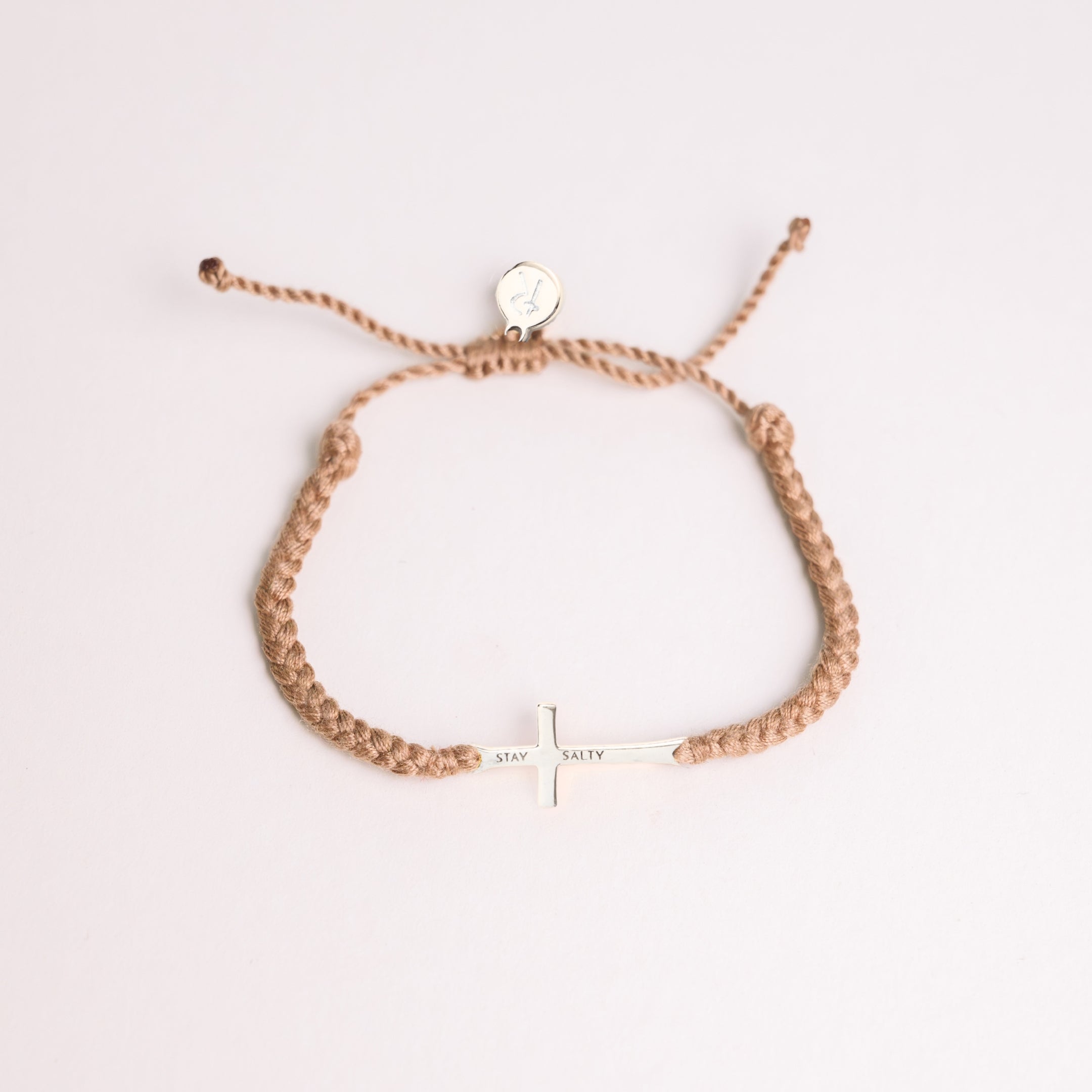 Cross bracelet engraved STAY SALTY set on a naturally dyed khaki hand-braided, cotton cord friendship bracelet with a gold or sterling silver finish from the Made4Ministry Collection by Rizen Jewelry. 