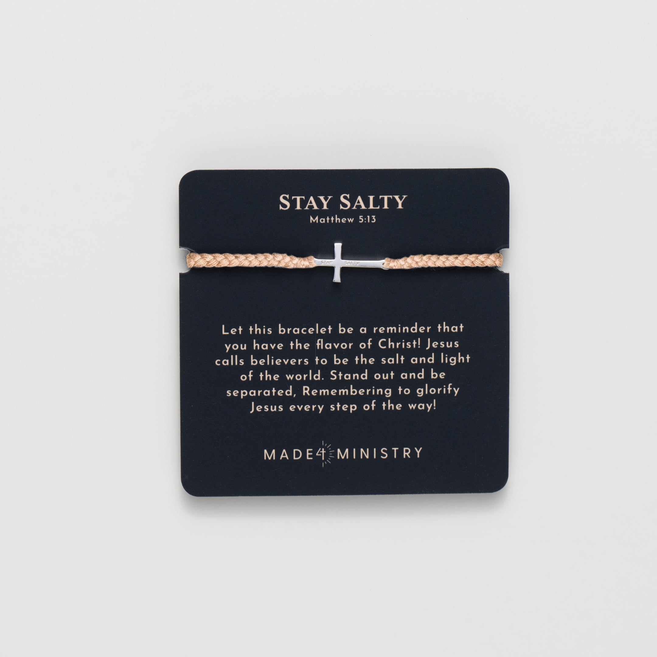 Cross bracelet engraved STAY SALTY set on a naturally dyed khaki hand-braided, cotton cord friendship bracelet with a gold or sterling silver finish from the Made4Ministry Collection by Rizen Jewelry. Featured on a devotion Card.