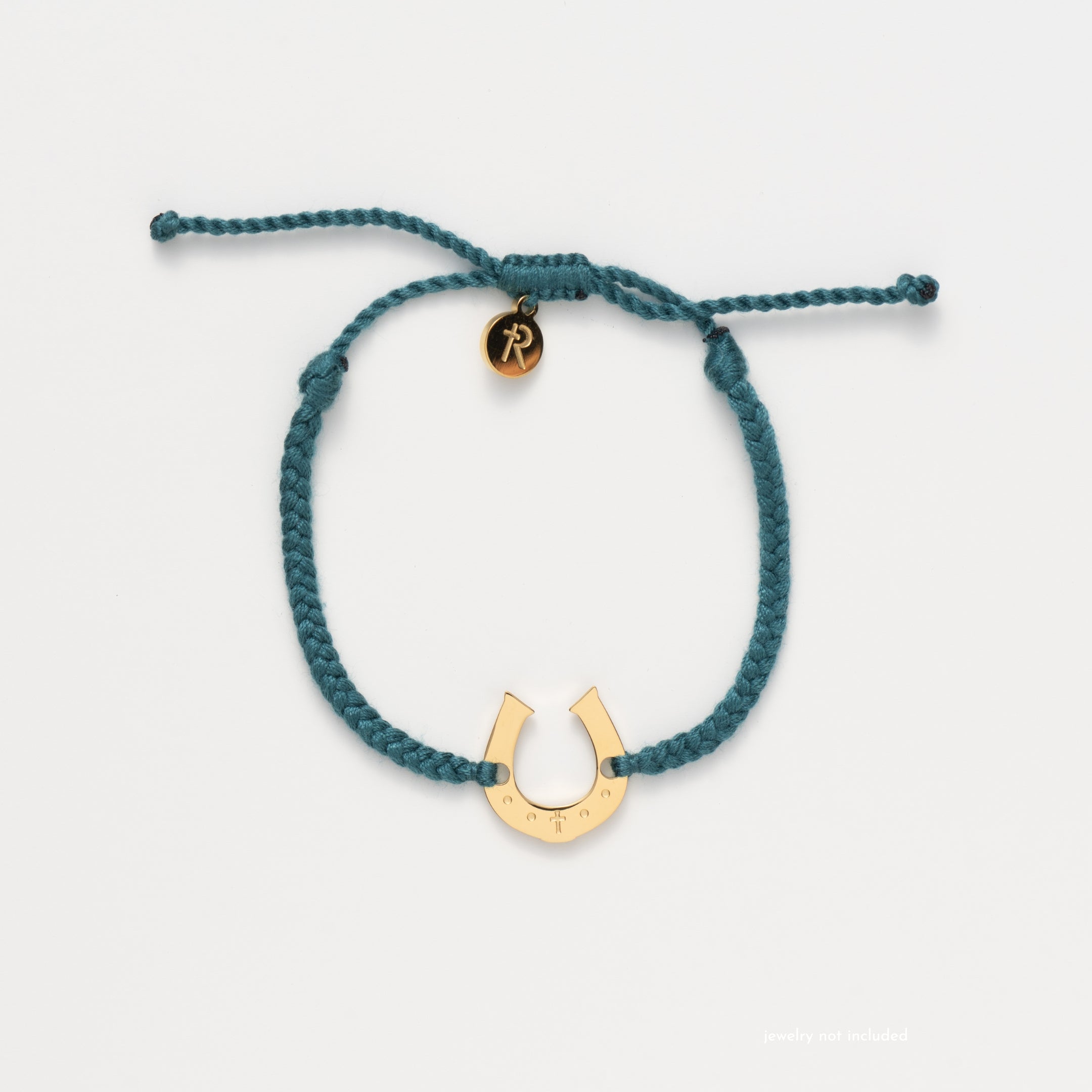 Horseshoe bracelet engraved with a cross set on a naturally dyed azure blue hand-braided, cotton cord friendship bracelet. Available in 18k Gold and Sterling Silver finish. From the Made4Ministry Collection by Rizen Jewelry.