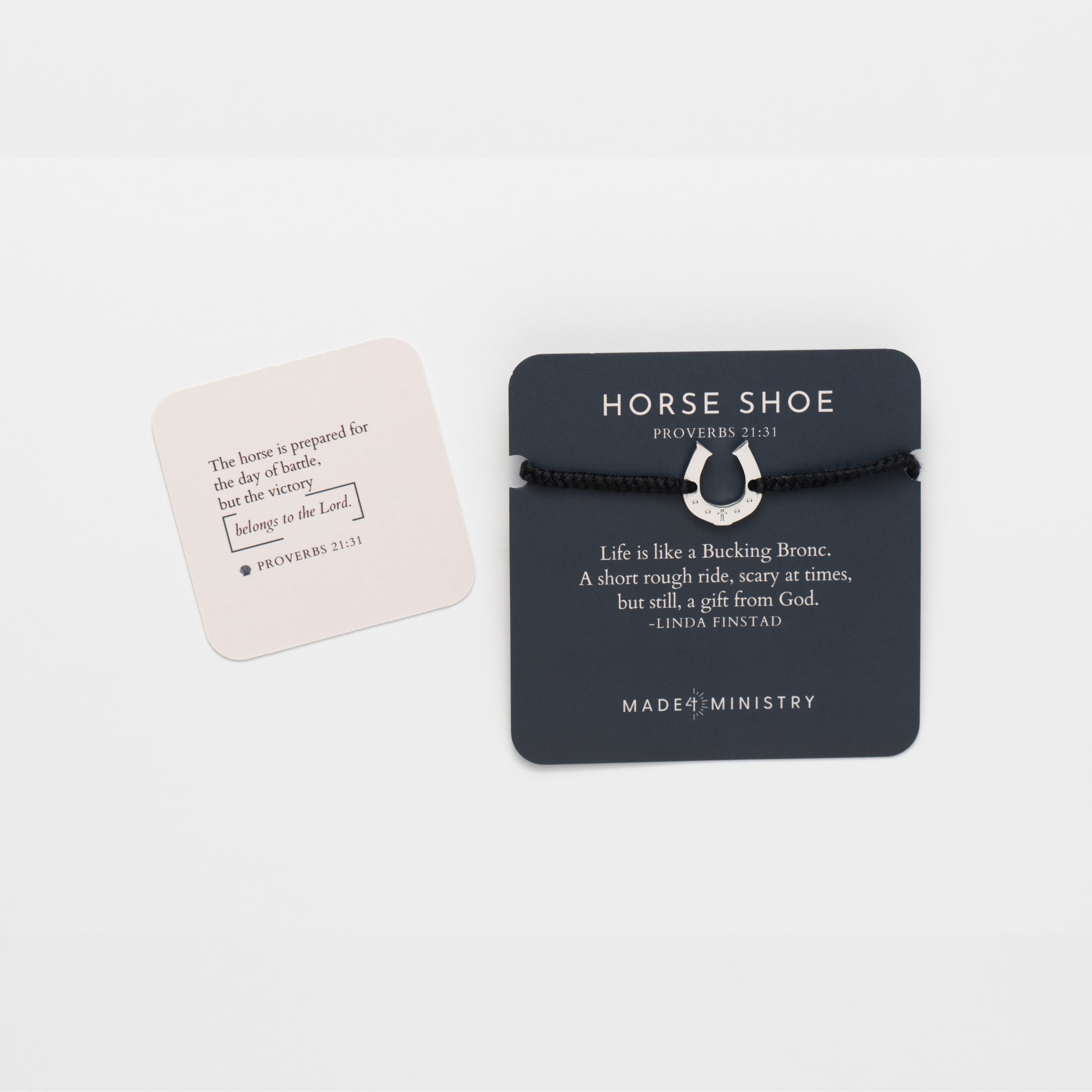 Horseshoe bracelet engraved with a cross set on a naturally dyed black hand-braided, cotton cord friendship bracelet. Available in 18k Gold and Sterling Silver finish. Featured on a devotion card next to the mini scripture card. 