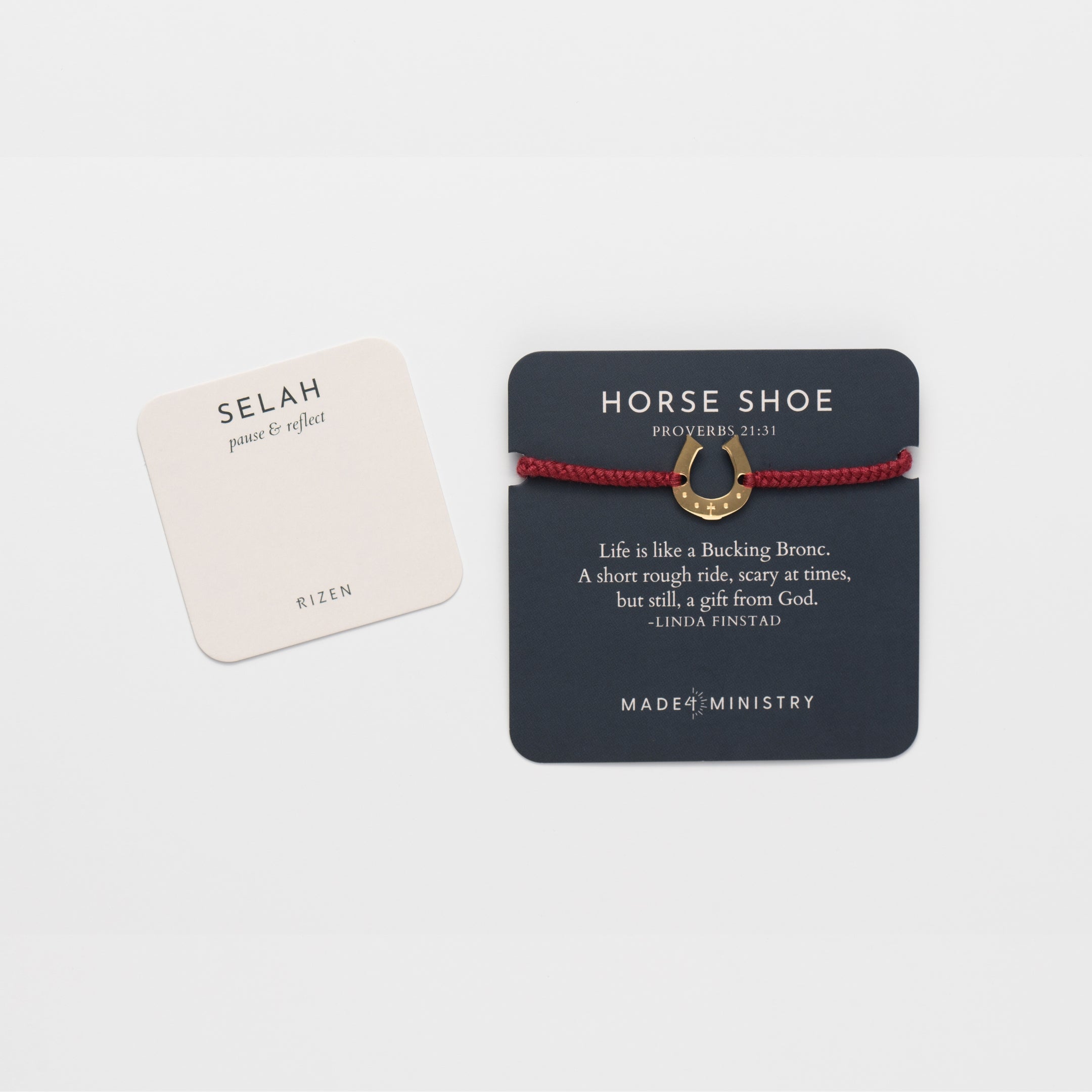 Horseshoe bracelet engraved with a cross set on a naturally dyed garnet red hand-braided, cotton cord friendship bracelet. Available in 18k Gold and Sterling Silver finish. Designed by Rizen Jewelry for the Made4Ministry Collection. Featured on Devotion rd next to a prayer card. 