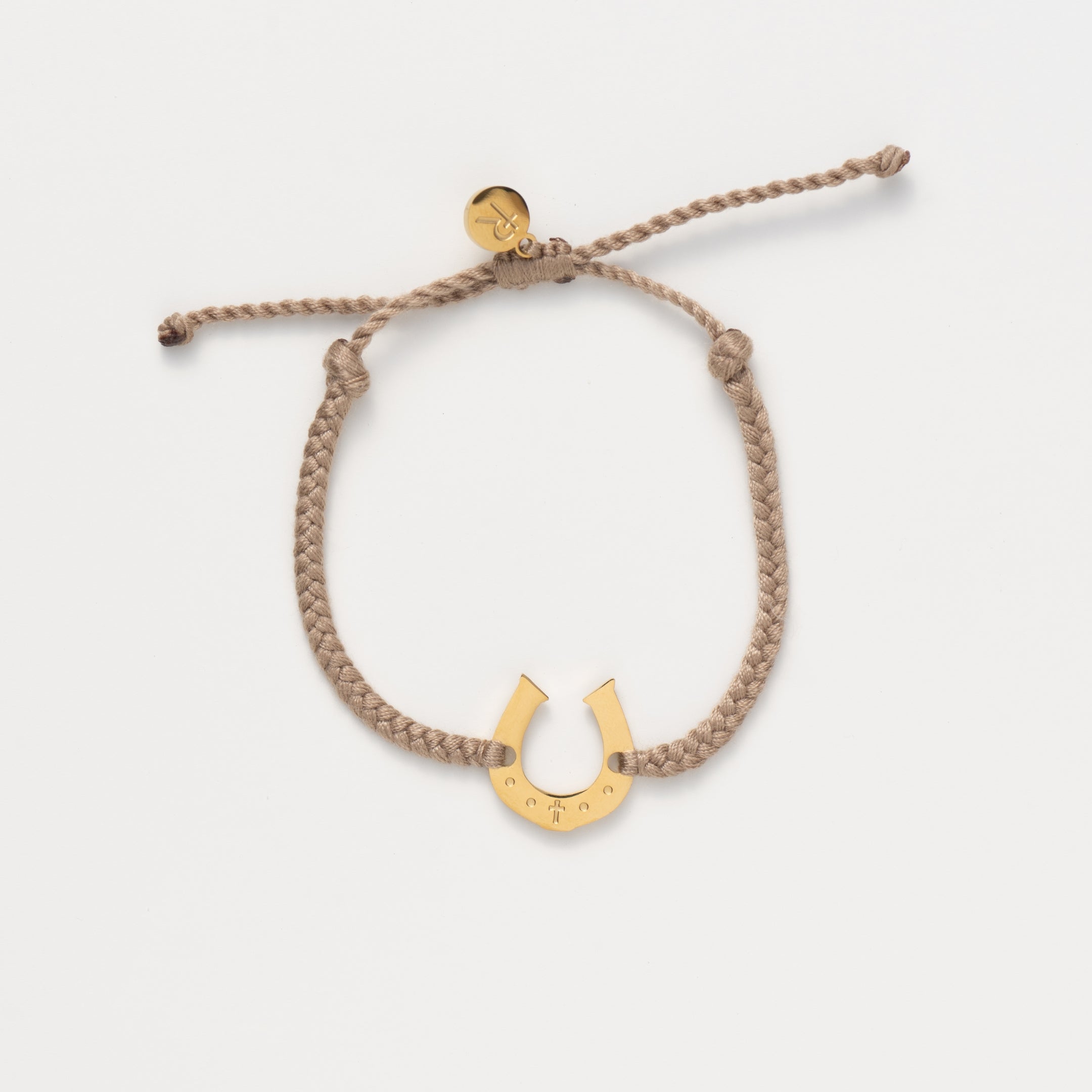 Horseshoe bracelet engraved with a cross set on a naturally dyed khaki hand-braided, cotton cord friendship bracelet. Available in 18k Gold and Sterling Silver finish. From the Made4Ministry Collection by Rizen Jewelry.