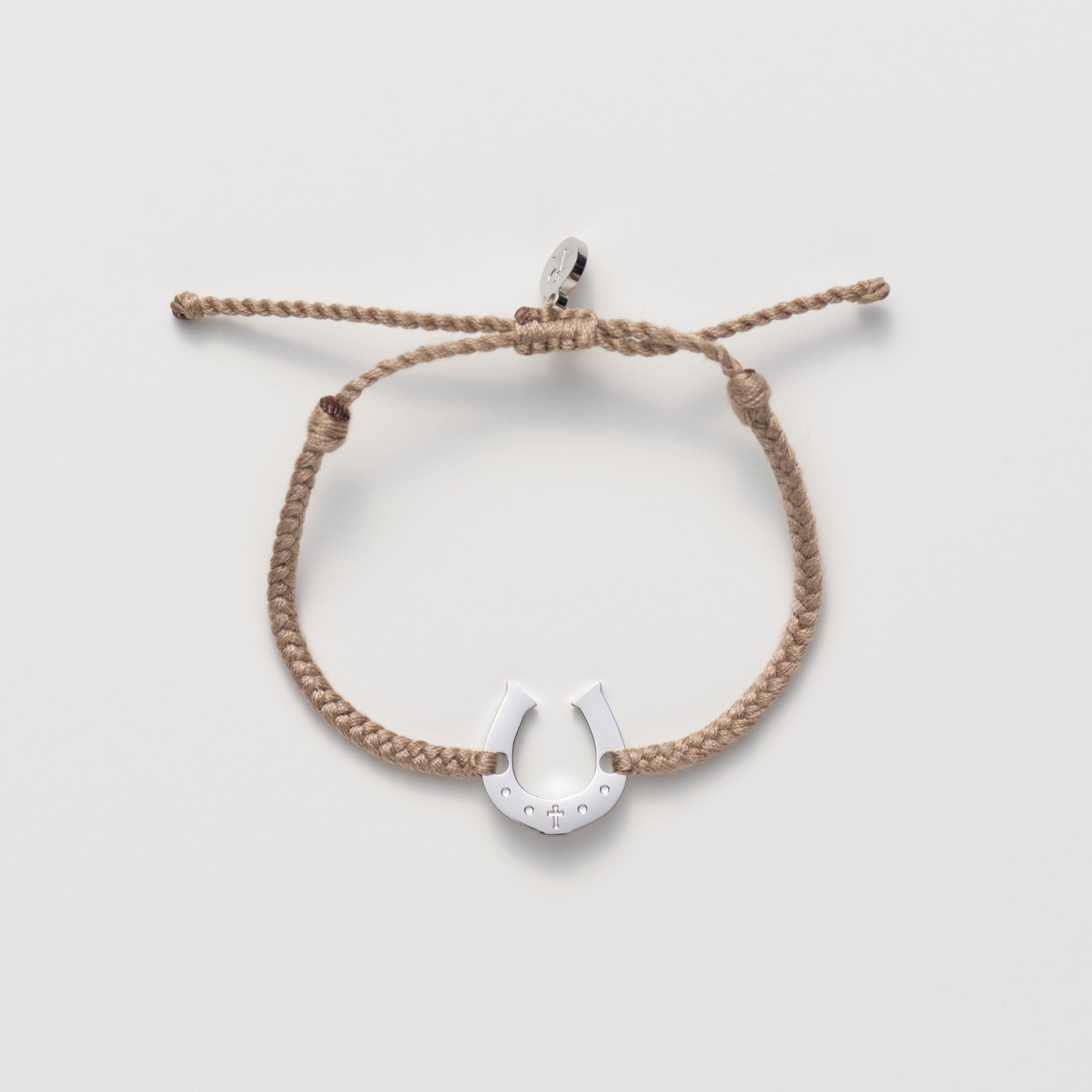Horseshoe bracelet engraved with a cross set on a naturally dyed khaki hand-braided, cotton cord friendship bracelet. Available in 18k Gold and Sterling Silver finish. From the Made4Ministry Collection by Rizen Jewelry.