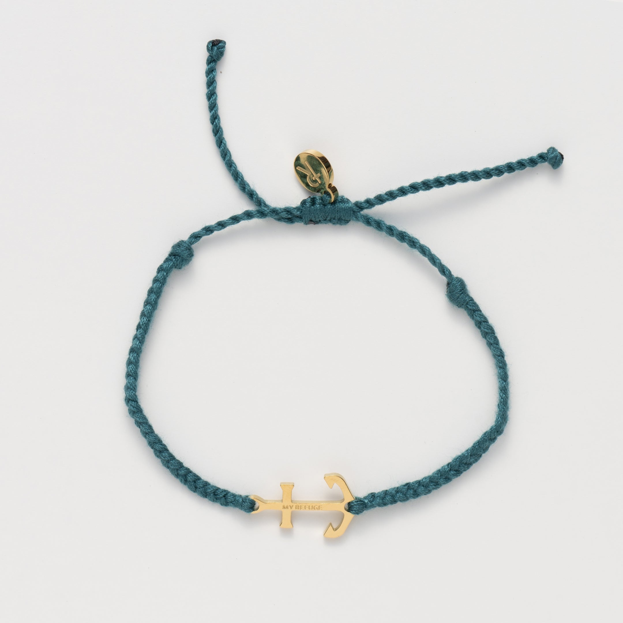 Classic nautical anchor bracelet, delicately engraved with the inscription “MY REFUGE,” hand-braided from naturally dyed azure blue cotton cord. Available in 18k gold or sterling silver finish from the Made4Ministry Collection by Rizen Jewelry. 