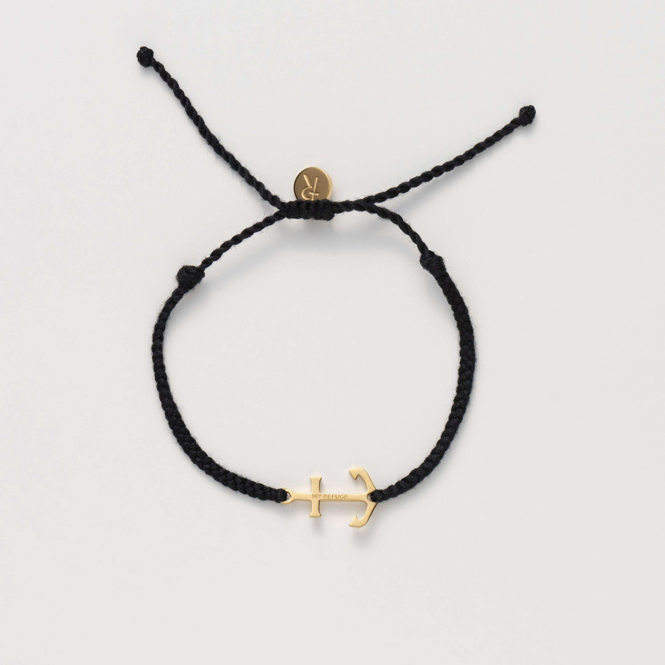 Classic nautical anchor bracelet, delicately engraved with the inscription “MY REFUGE,” hand-braided from naturally dyed black cotton cord. Available in 18k gold or sterling silver finish from the Made4Ministry Collection by Rizen Jewelry. 