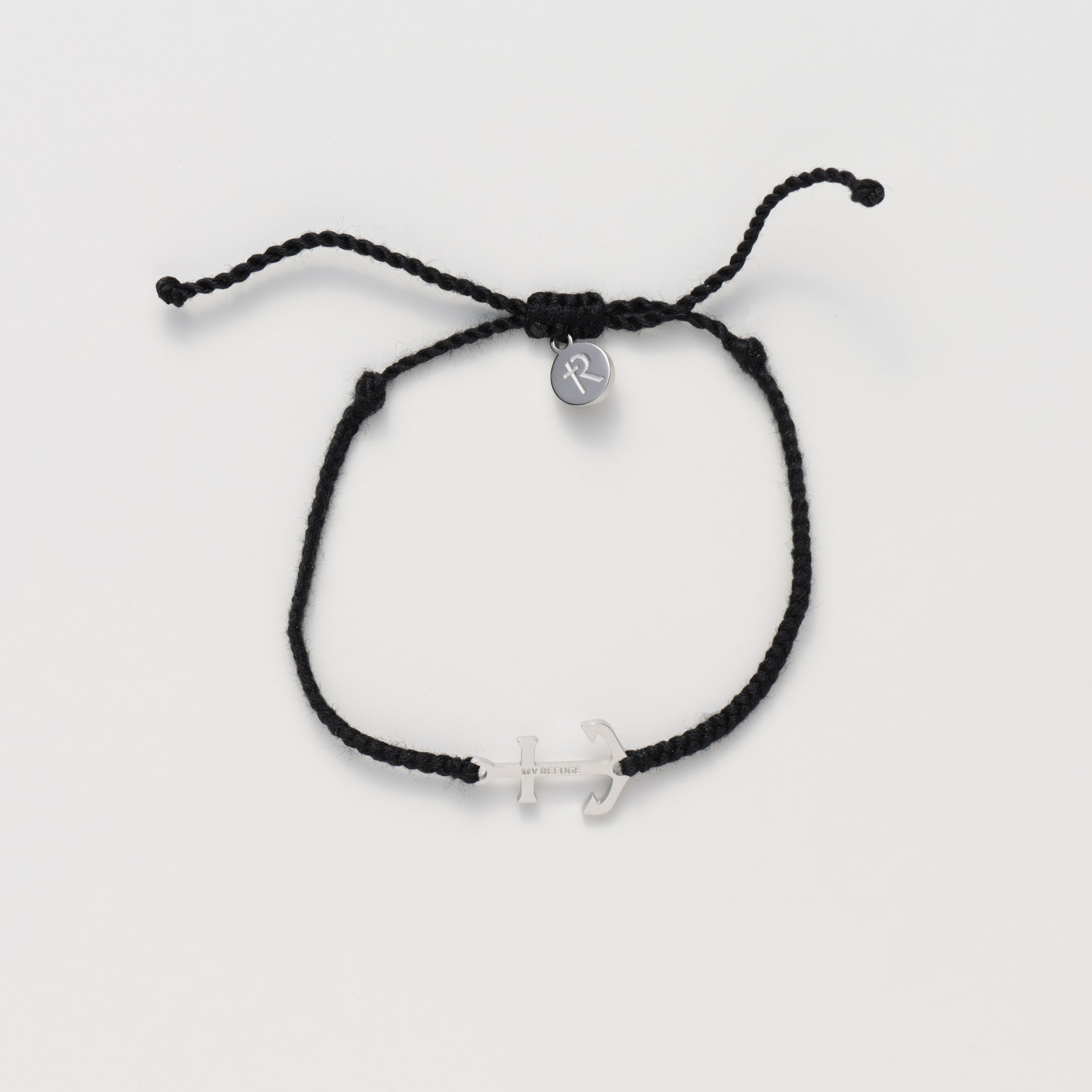 Classic nautical anchor bracelet, delicately engraved with the inscription “MY REFUGE,” hand-braided from naturally dyed black cotton cord. Available in 18k gold or sterling silver finish from the Made4Ministry Collection by Rizen Jewelry. 