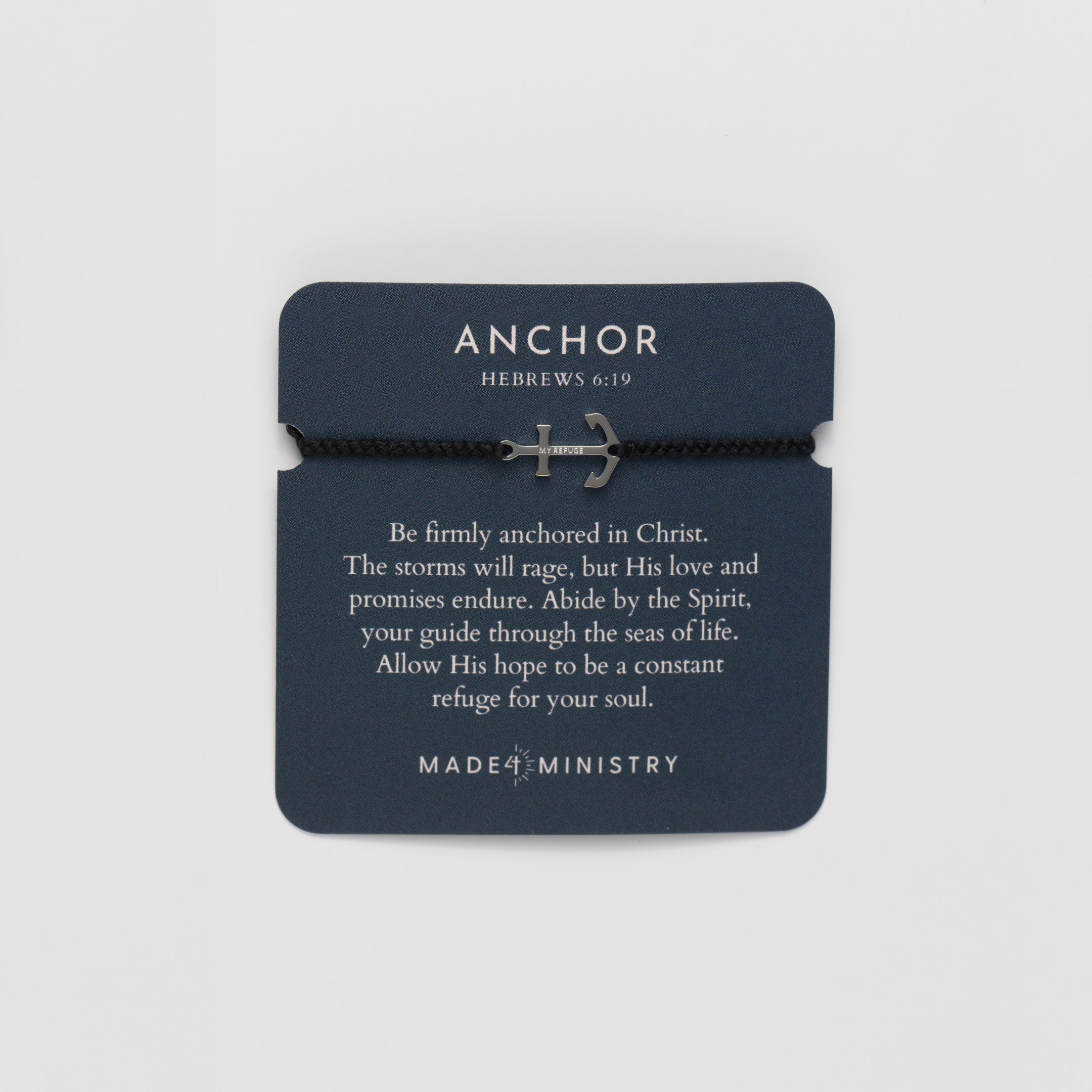 Inspirational devotion card featuring the classic nautical anchor bracelet, delicately engraved with the inscription “MY REFUGE,” hand-braided from naturally dyed black cotton cord. Available in 18k gold or sterling silver finish from the Made4Ministry Collection by Rizen Jewelry. 