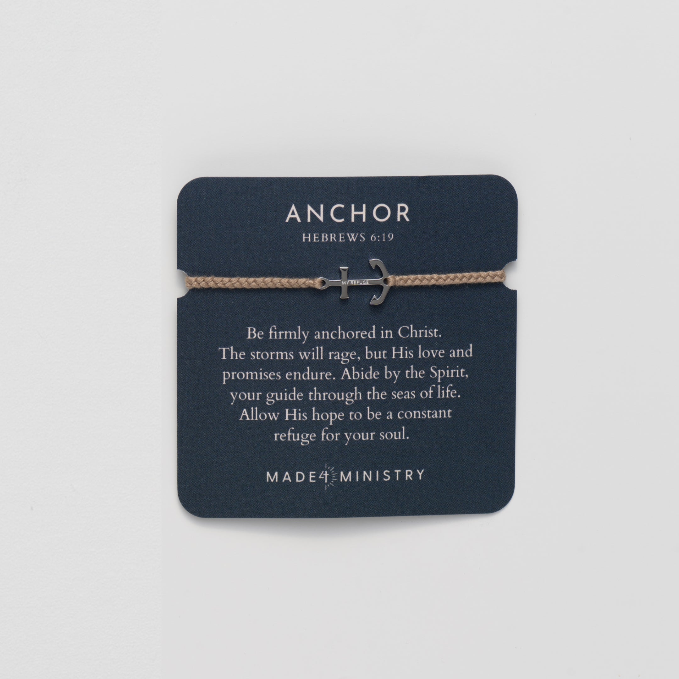 Gold anchor set on a khaki friendship bracelet with the engraving MY REFUGE from the Made4Ministry collection by Rizen Jewelry on an inspirational devotion card. 
