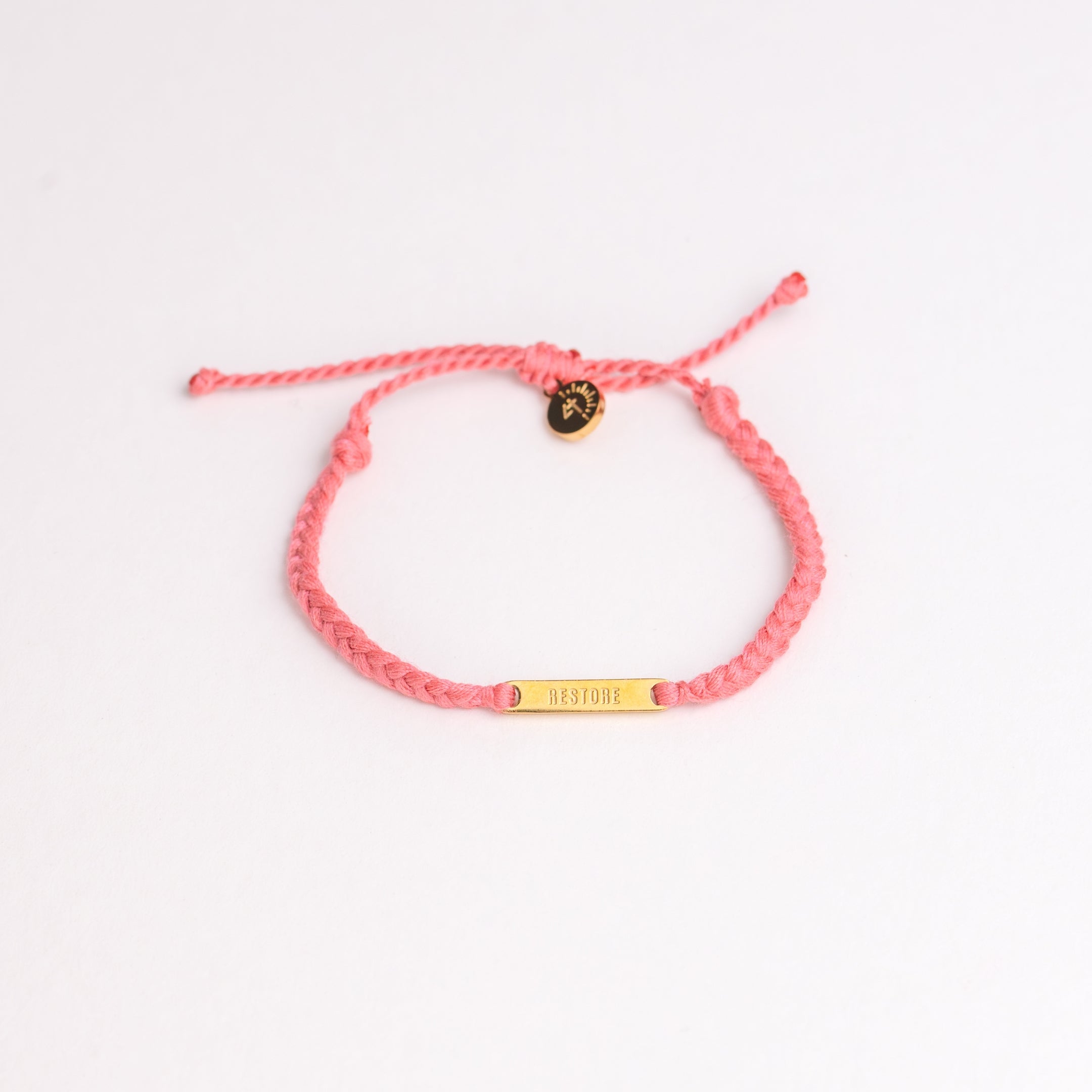 Restore Made4Ministry pink dusty rose cord bracelet x Britt Nicole from her new album IIV featuring the verse Joel 2:25. The gold bar pendant is engraved RESTORE on the front. 