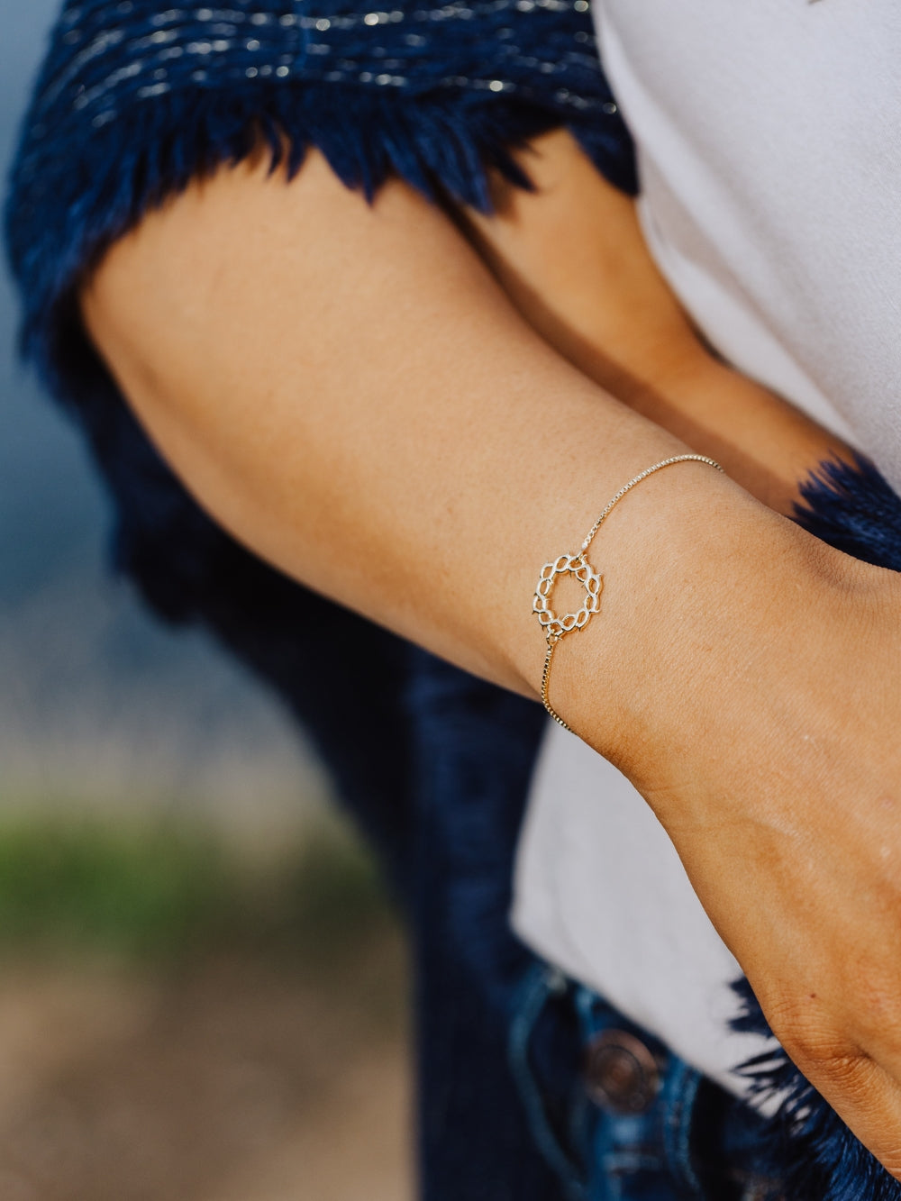 Women's Christian jewelry model is wearing the Crown of thorns bracelet in 18k gold plated from the Insignia collection. A timeless baptism gift by Rizen Jewelry.