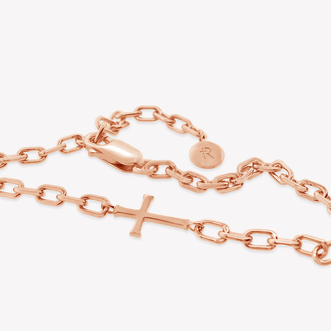 Close up of Mini Chain Breaker Cross Bracelet in 18k rose gold plated from the Calvary collection by Rizen Jewelry highlighting that the lobster clasp works on every link.  