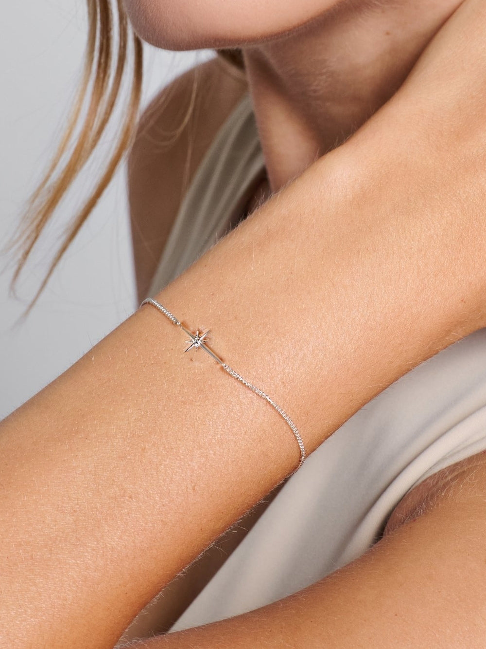 Model wearing the sterling silver Adoring Star Bracelet on her wrist, designed by Rizen Jewelry. 