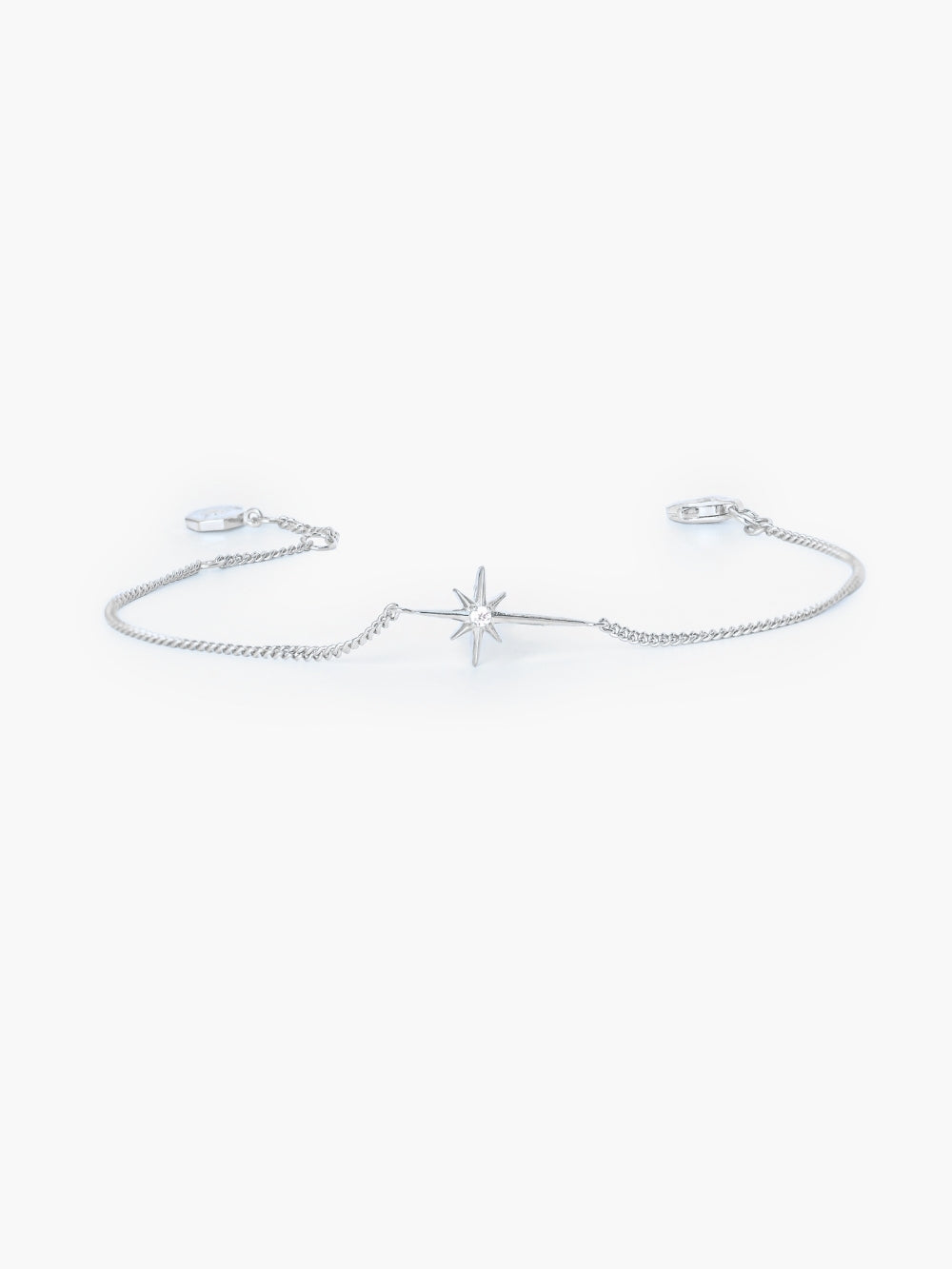 Close-up of the star-cross charm showing the 2mm cubic zirconia center, of the silver Adoring Star Bracelet by Rizen Jewelry. 