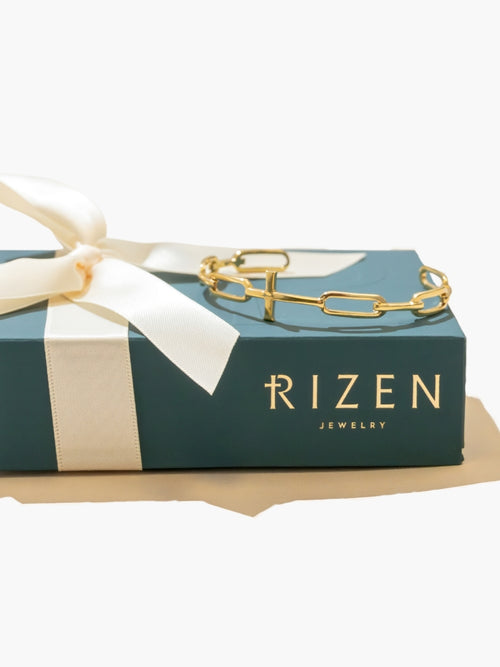 Bold yet sleek cross cuff bangle featuring striking links seamlessly transitioning into the classic Rizen Cross in heavy 18k gold plating. Featured on Rizen packaging. 