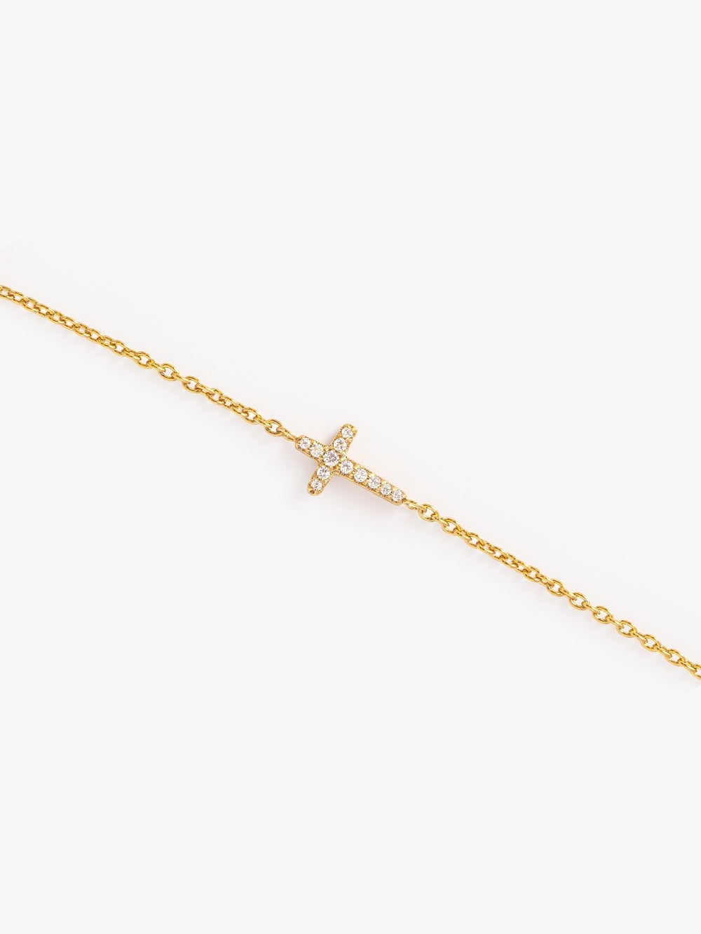 Close-up of the pavé cross centerpiece, on the Dainty Luminous Cross Pave Bracelet, showing the largest crystal at the heart of the design by Rizen Jewelry.