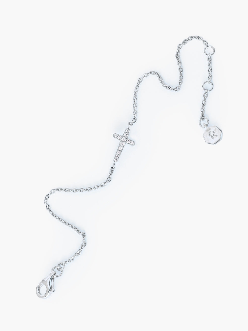 The silver Dainty Luminous Cross Pavé Bracelet showing three length settings on the adjustable cable chain by Rizen Jewelry.
