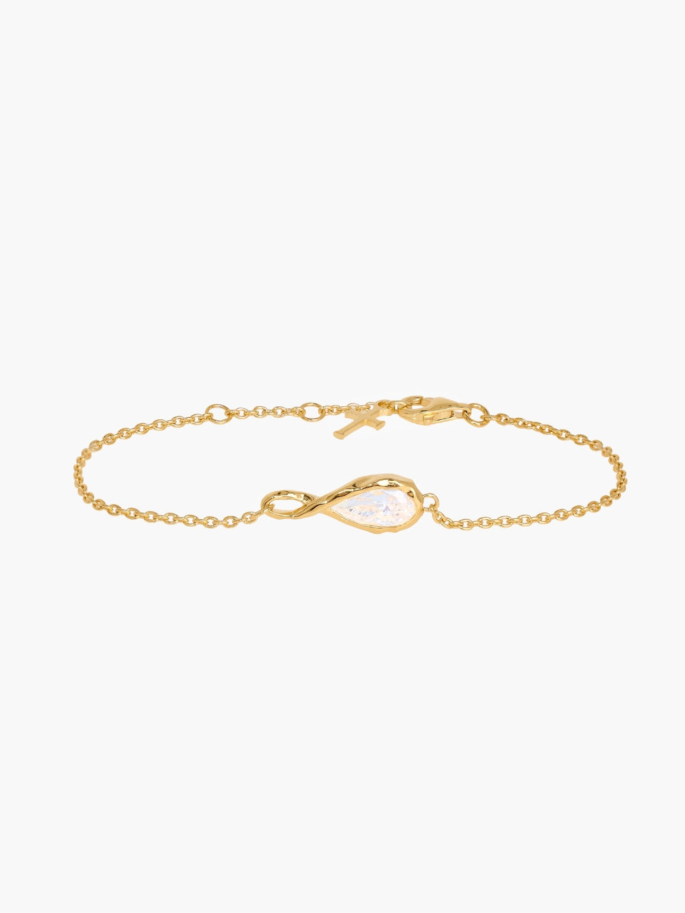 Rizen Jewelry's Solace Teardrop Bracelet is set on a delicate gold cable chain bracelet featuring a teardrop-shaped pendant with a clear faceted gemstone, a small gold cross charm, and a lobster clasp, displayed on a clean white background.