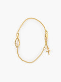 Rizen Jewelry's Solace Teardrop Bracelet is set on a delicate gold cable chain bracelet featuring a teardrop-shaped pendant with a clear faceted gemstone, a small gold cross charm, and a lobster clasp, displayed on a clean white background.