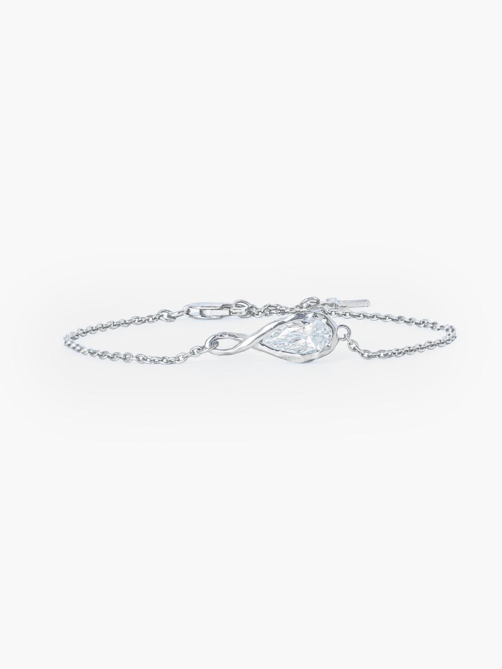 Rizen Jewelry Solace Teardrop Bracelet is a delicate silver cable chain bracelet with a teardrop infinity pendant with a teardrop shaped simulated diamond also has a lobster clasp and signature Rizen Cross Pendant Tag. 