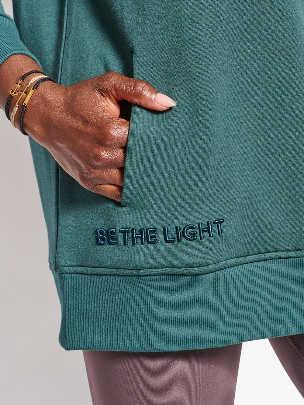 Close up of Hope crew neck sweatshirt with BE THE LIGHT embroidery, and discreet front pockets.