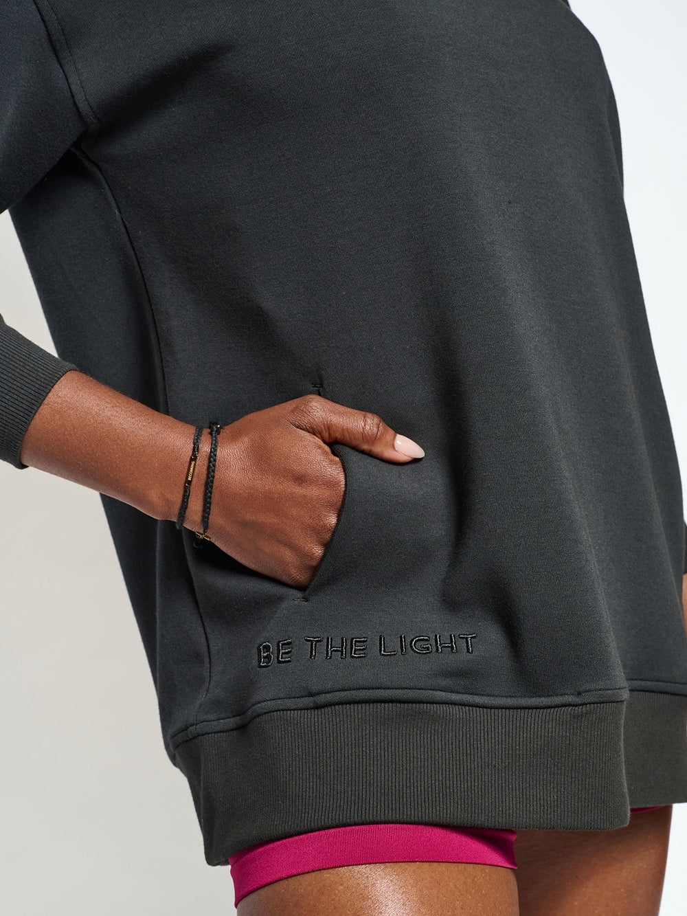 Close up of woman wearing the Chosen crew neck sweatshirt with BE THE LIGHT embroidery,  and discreet front pockets