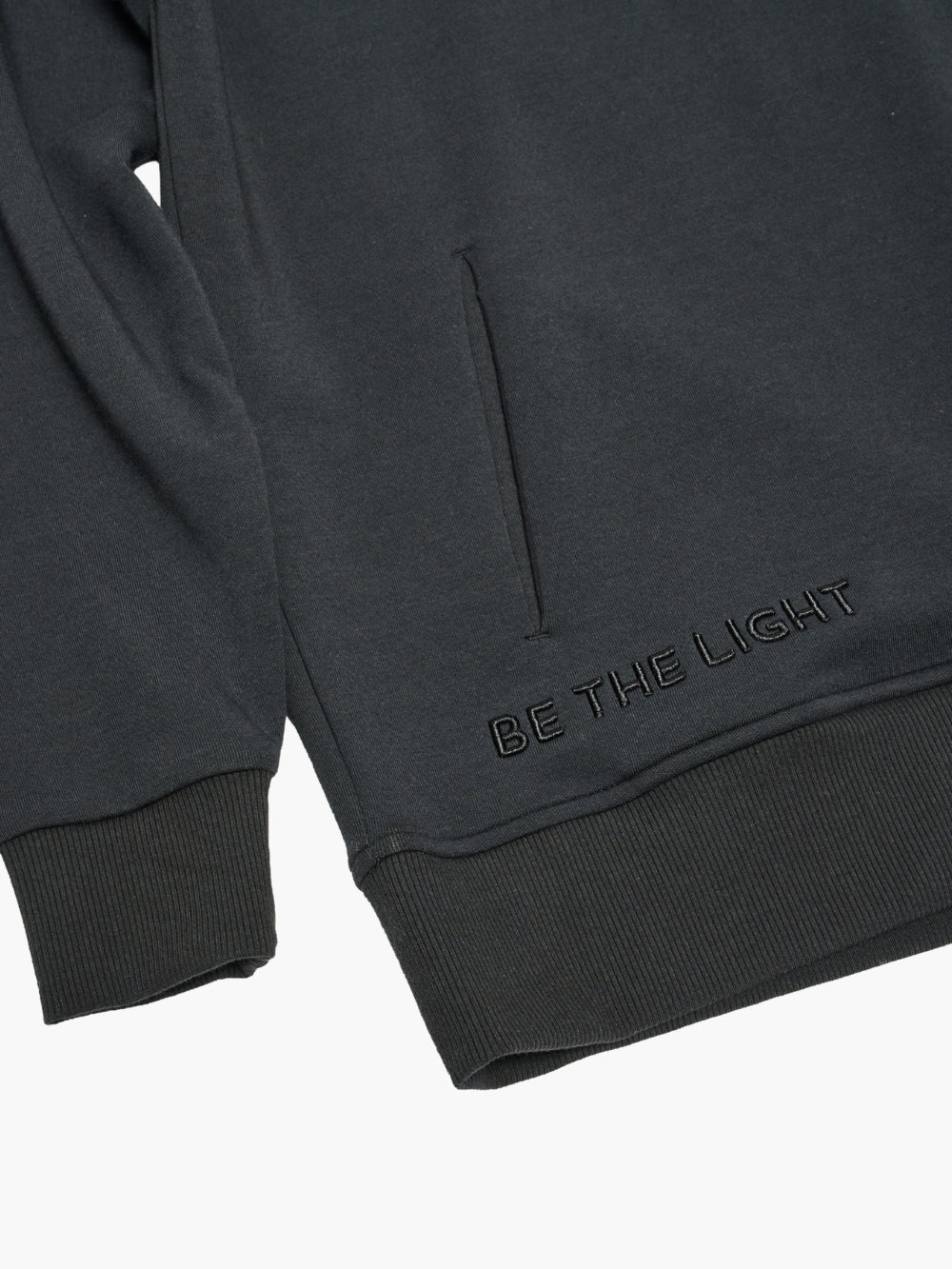 Close-up of Chosen crew neck sweatshirt with"Be the Light embroidery, and discreet front pockets