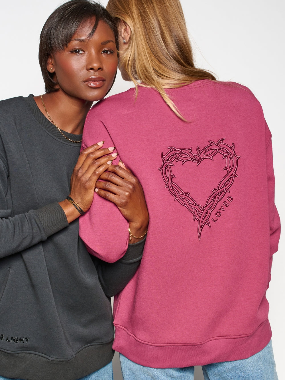 Premium christian female sweatshirt models wearing Be The Light crewneck sweatshirts: Midnight Black Chosen and the Loved John 3:16 sweatshirts styled with jeans.