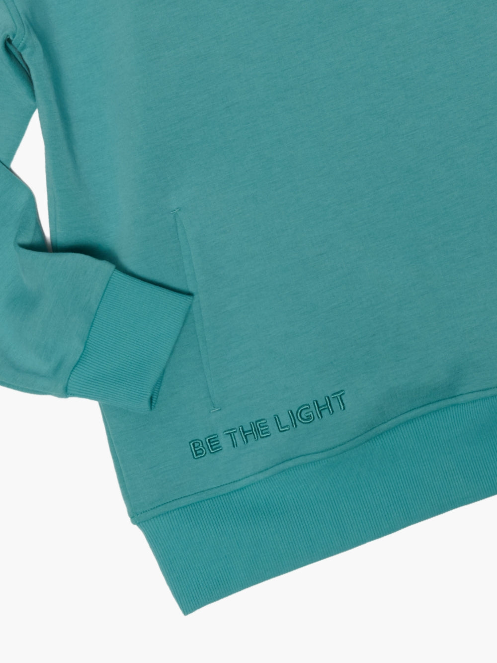 Closu-up of Stay Salty crew neck sweatshirt with BE THE LIGHT embroidery,  and discreet front pockets