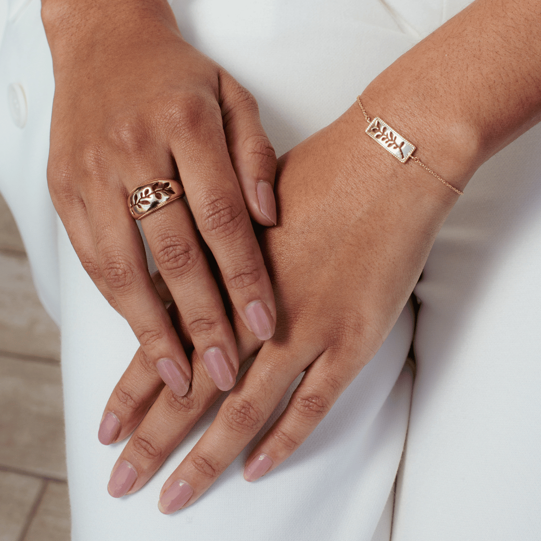 Close up of christian woman's hands wearing the 18k gold vermeil Olive Branch Ring and Bracelet from the Rooted Collection by Rizen Jewelry. 