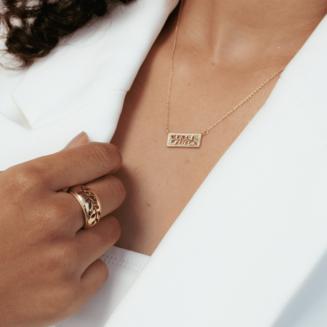 Close up of christian woman wearing 18k gold vermeil Olive Branch Ring and Necklace from the Rooted Collection by Rizen Jewelry.