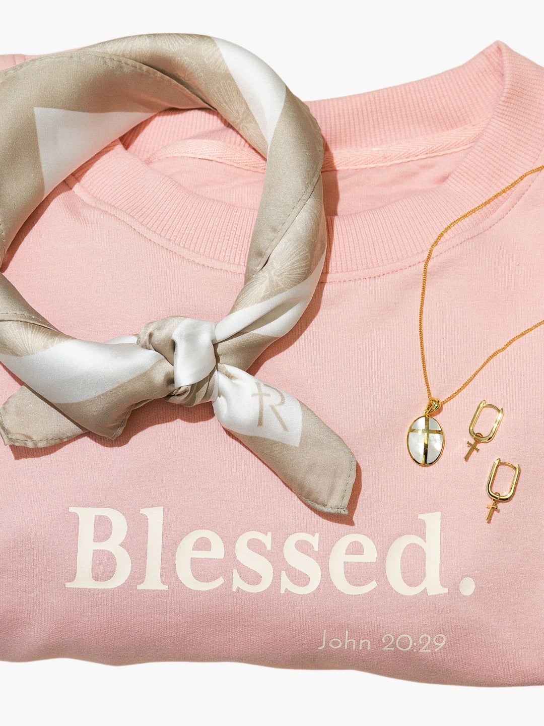 Rizen scarf styled with Blessed Be The Light sweatshirt, becoming gold cross mother pearl necklace, and chain breaker hoop cross earrings 