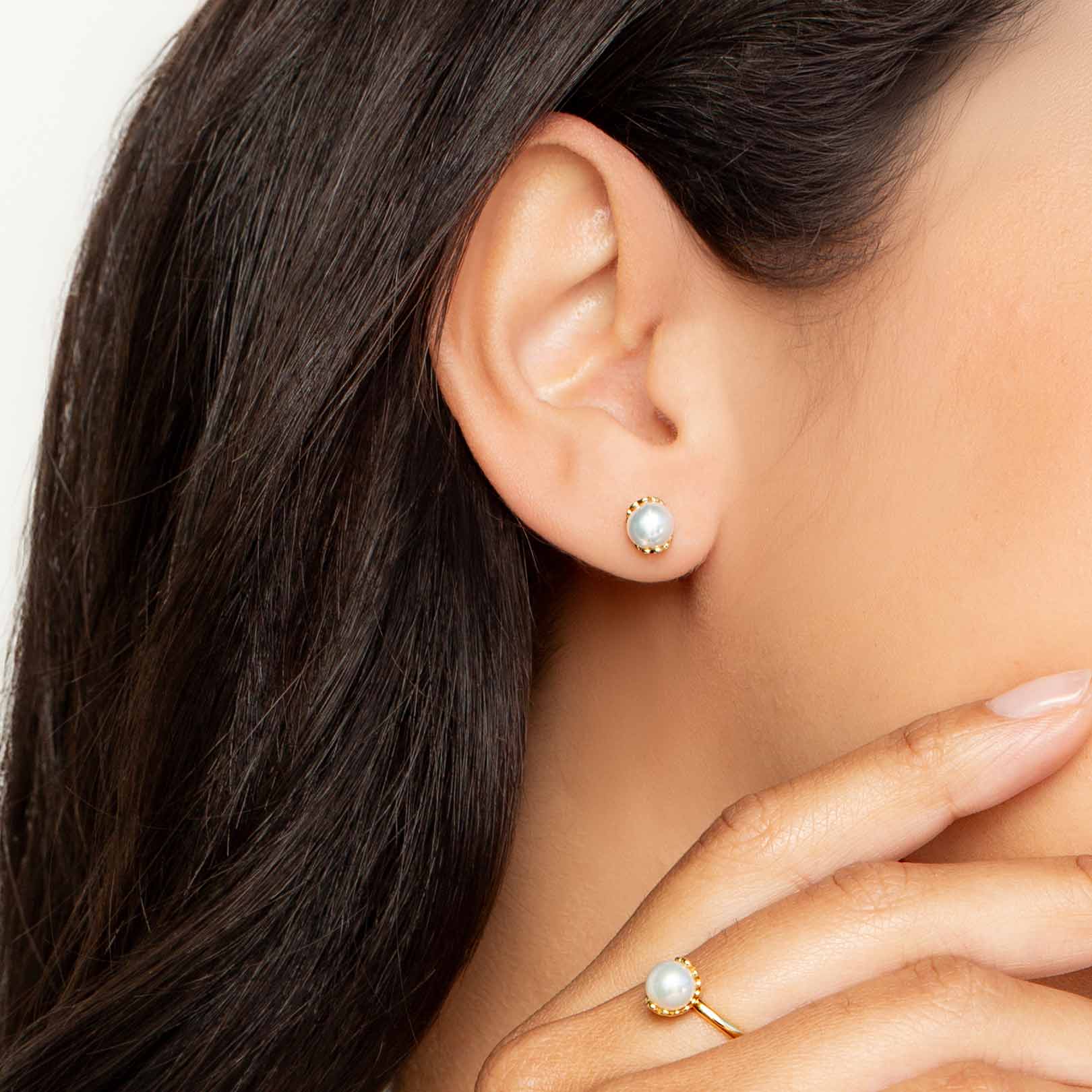 Close up of a christian woman wearing the 18k gold vermeil Shell Encased Pearl Earring and Ring from the Becoming Collection by Rizen Jewelry.