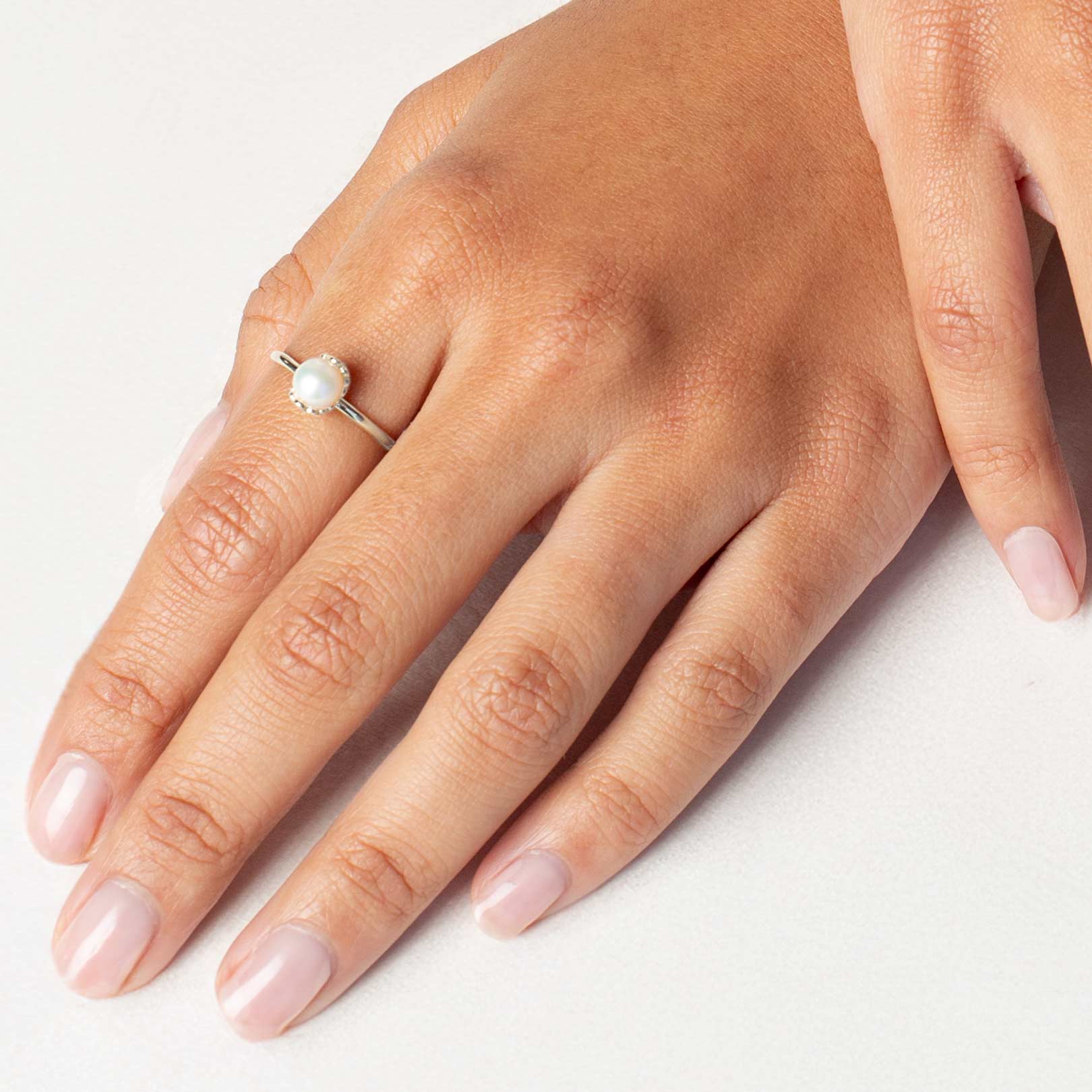 Close up of a christian woman wearing the sterling silver Shell Encased Pearl Ring from the Becoming Collection by Rizen Jewelry.