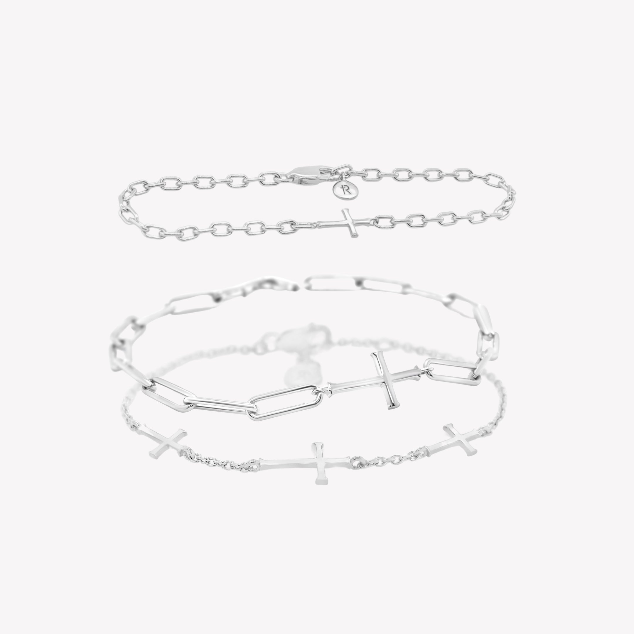 A three-piece sterling silver cross bracelet set featuring a Calvary cross bracelet and two additional chain breaker cross bracelets from Rizen Jewelry. 