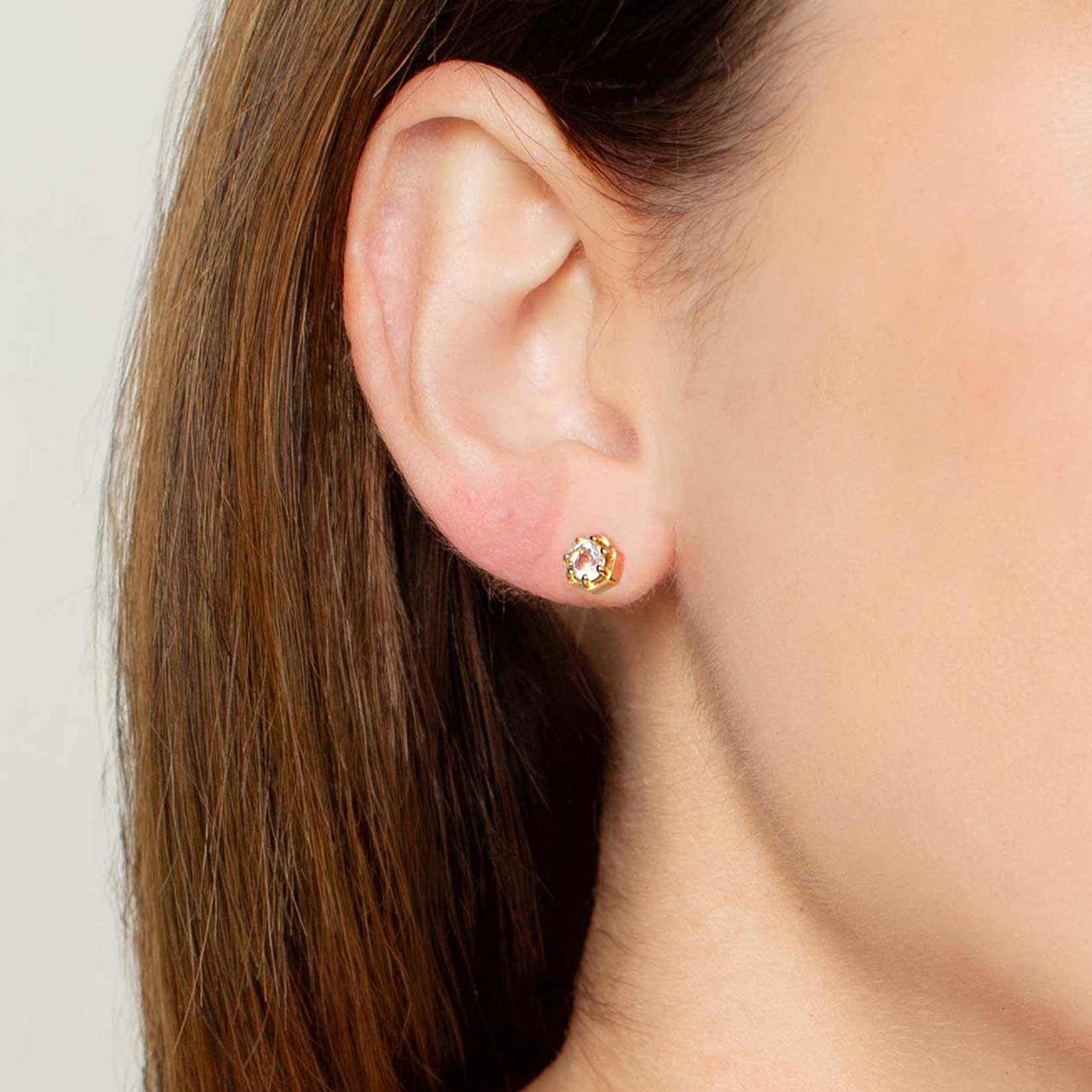 Close up of a christian woman wearing 18 gold vermeil white topaz Ebenezer Solitaire Earring and Ring from the Chispa Collection by Rizen Jewelry.