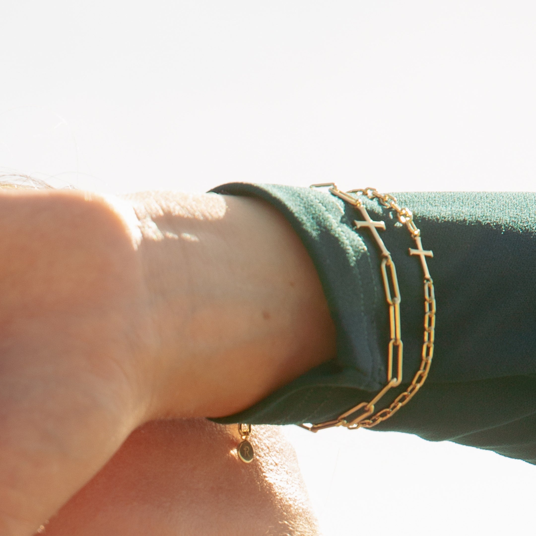 Christian jewelry model wearing the 18k gold-plated chain breaker cross bracelets from Rizen Jewelry. 