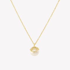 Rizen Jewelry shell encased pearl necklace in gold vermeil from the Becoming Collection.